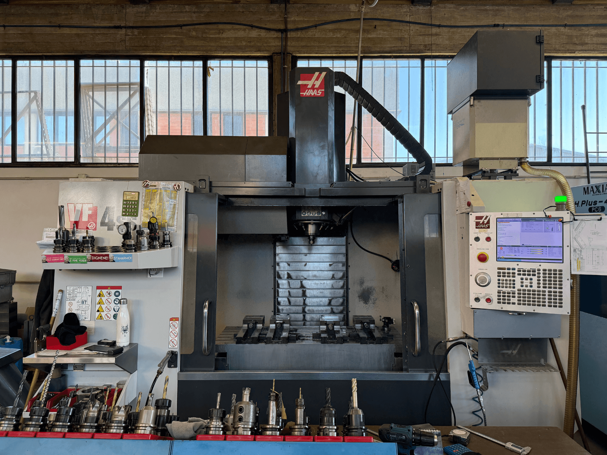 HAAS VF-4SS vertikaalne töötlemiskeskus, vaade eest, millel on näha juhtpaneel, tööriistahoidikud ja spindli piirkond.