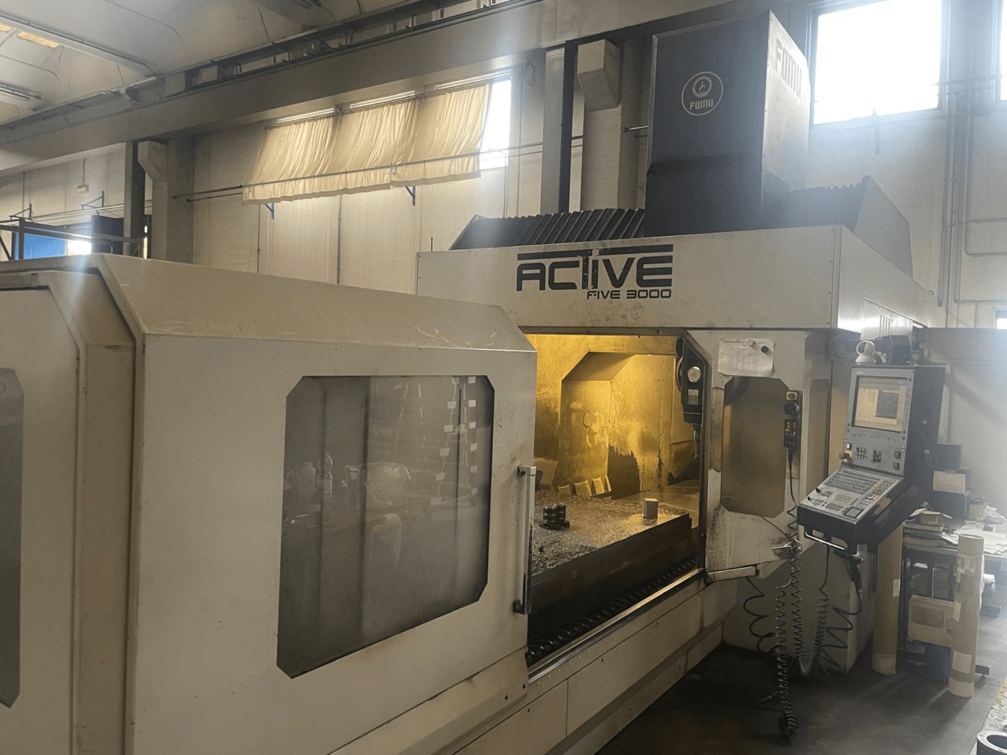 ACTIVE Five 3000 CNC-pingi esivaade, kus on näidatud juhtpaneel ja tööala, mille sees on osaliselt töödeldud detail.