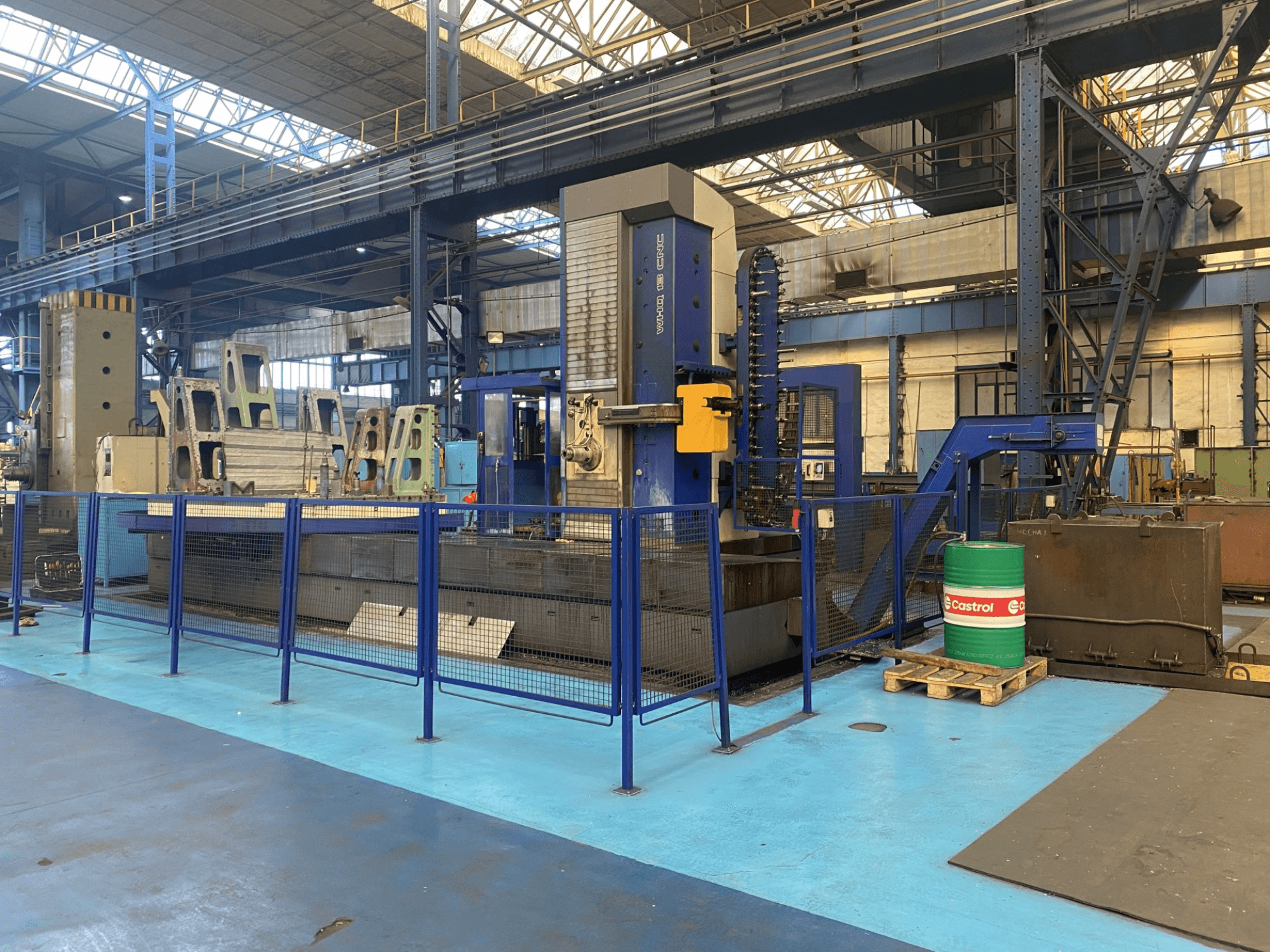 TOS WHQ 13 CNC-puurmasin töökojas, esivaade, millel on sinine raam ja ümbritsev kaitsepiirde.