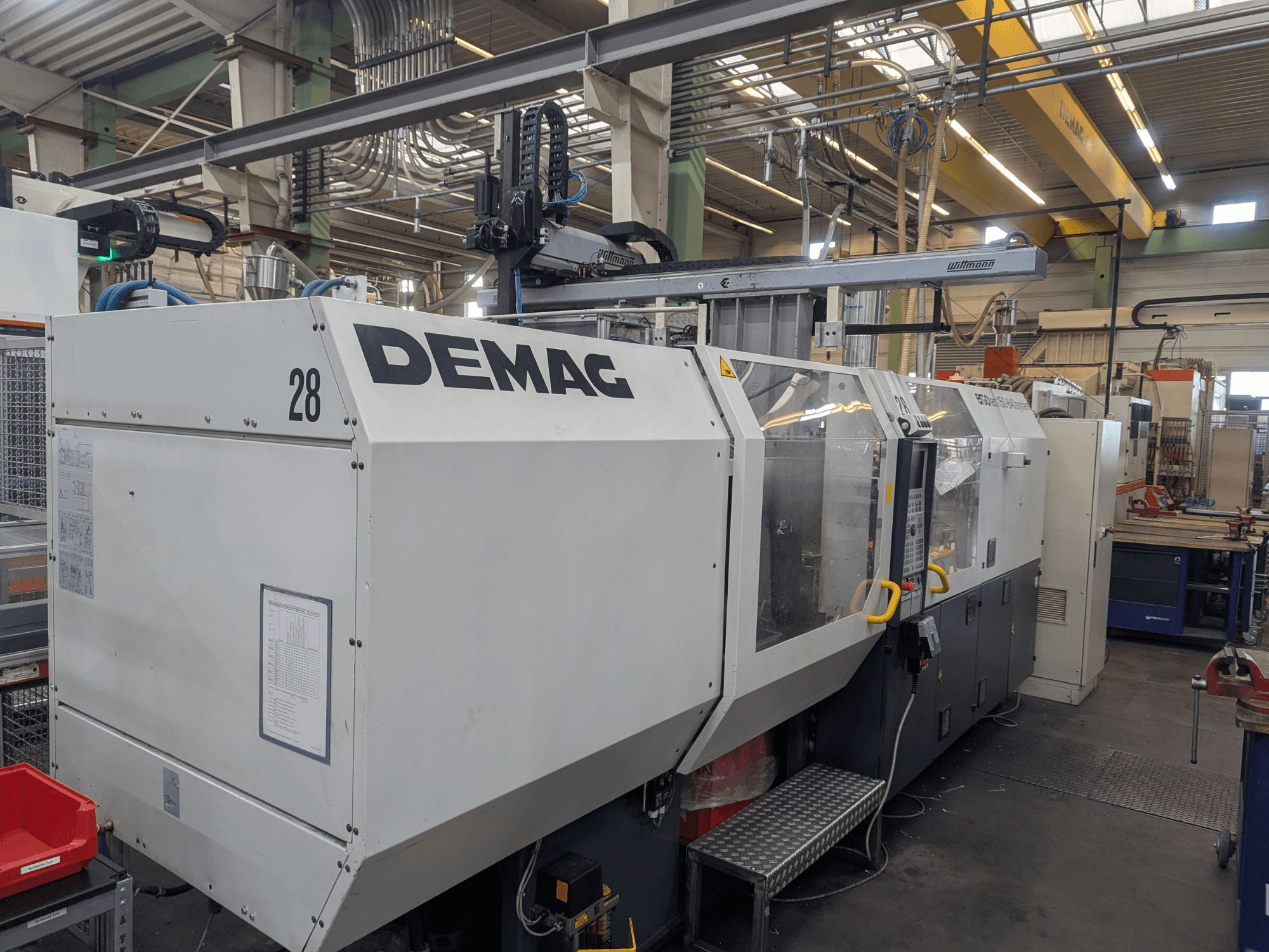 DEMAG ERGOTECH 1500-840 hüdraulilise survevalu masina esiplaanil, kus on näidatud juhtimisseadmed ja turvaelemendid.