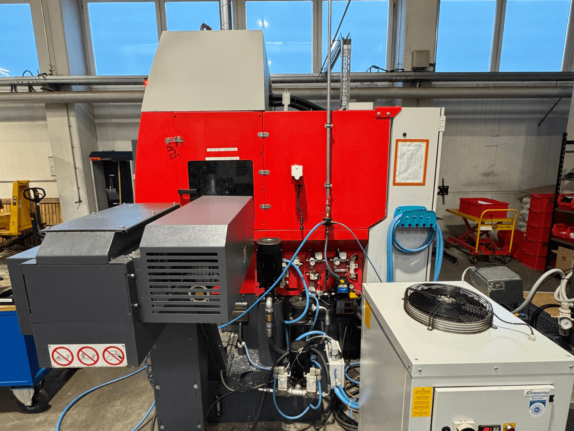 EMCO MAXXMILL 350 vertikaalne töötluskeskus, esiplaanil, kus on näha keerukaid masinaid ja juhtpaneeli üksikasju.