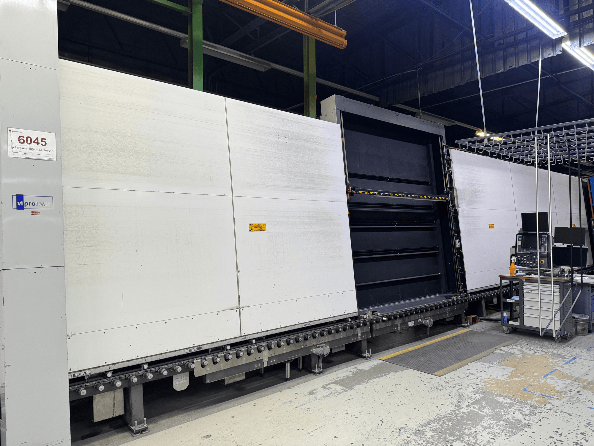 Vipro vormimismasina esivaade avatud paneeliga, mis näitab töötavaid seadmeid ja tööruumi selle kõrval. Mudel 6045.