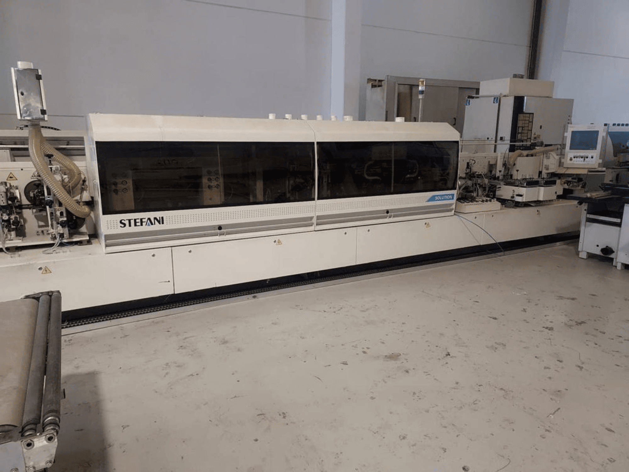 Stefani Solutionsi servapaigaldusmasin, esivaade, kus on näha tolmueemaldussüsteem ja juhtpaneel, töökojas.