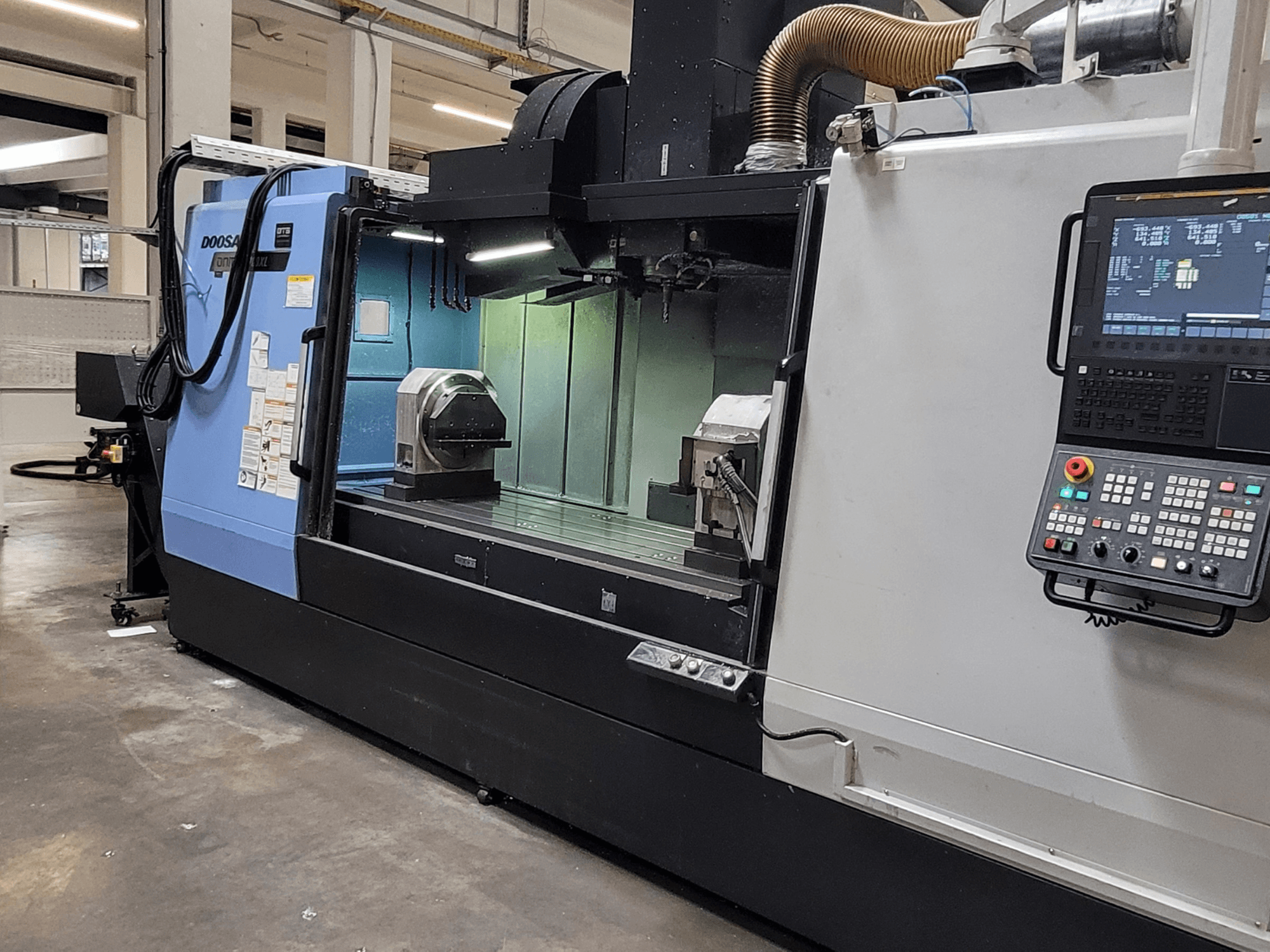 DOOSAN DNM 6700 XL vertikaalne töötlemiskeskus, esivaade, millel on näha juhtpaneel, tööpink ja töötlemisala.