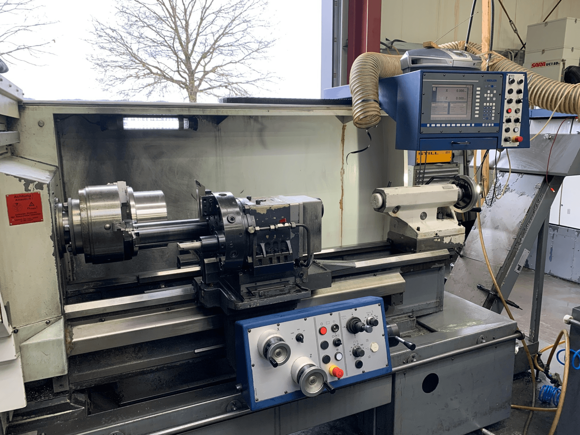 Weiler E55X1000 horisontaalne treipink töökojas, kus on näidatud juhtpaneel, treipink ja tööriistahoidik. Esiotsa.