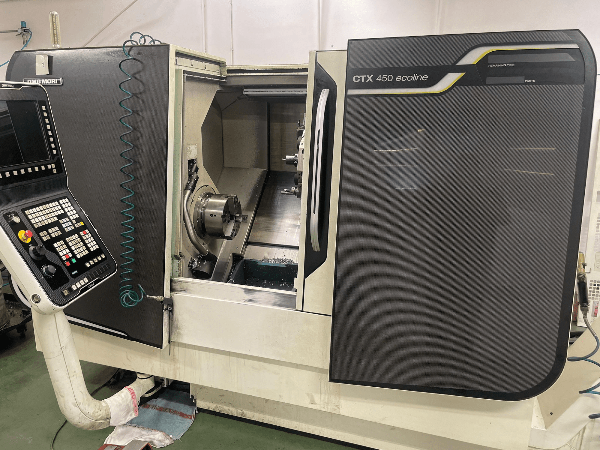 DMG MORI CTX 450 ecoline CNC-tööpingi külgvaates, kus on näidatud juhtpaneel, kinnituspint ja tööpiirkond.