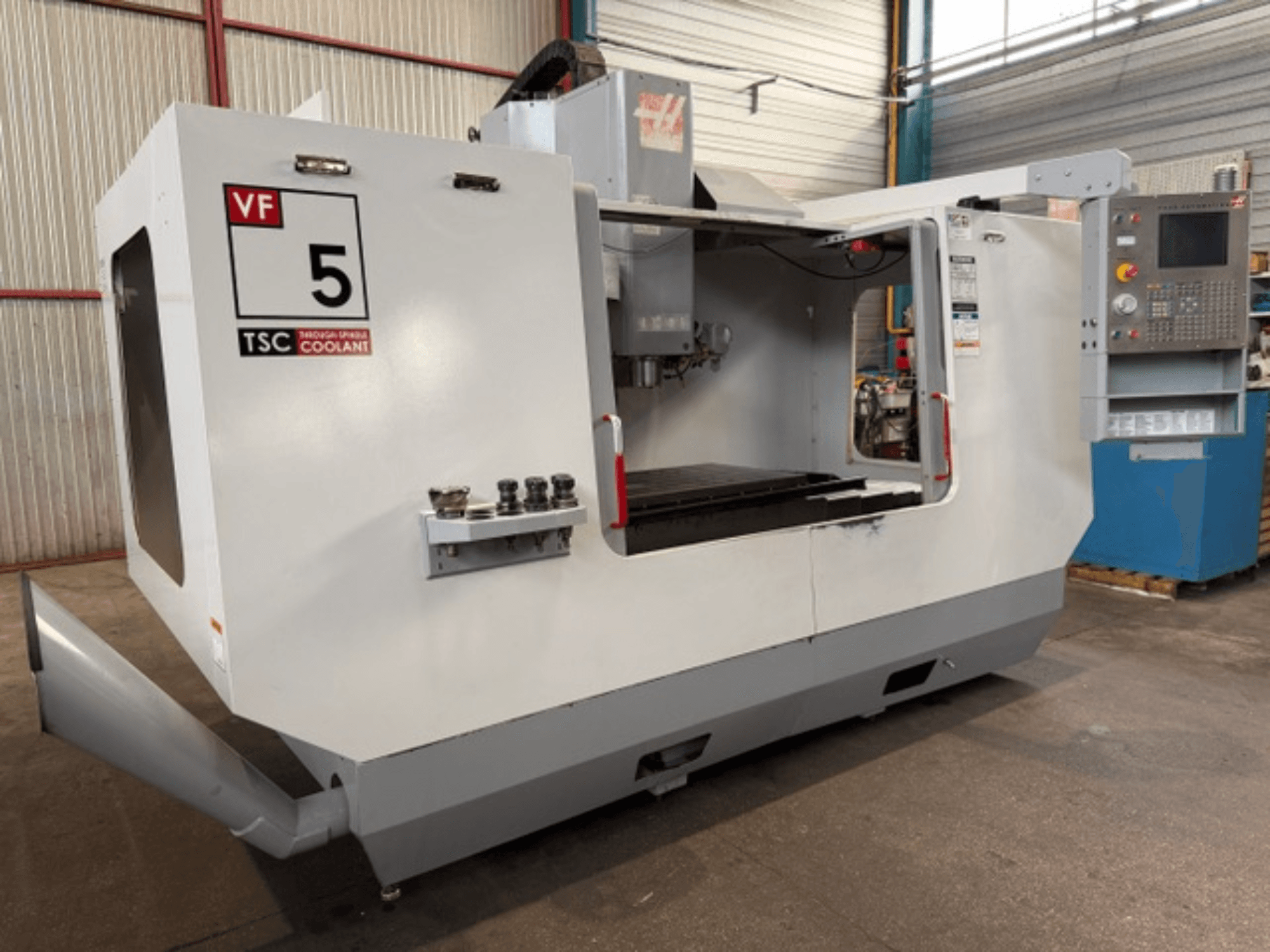 HAAS VF5-HE vertikaalne töötlemiskeskus, vaade eest, millel on näha TSC jahutussüsteem ja operaatori juhtpaneel.