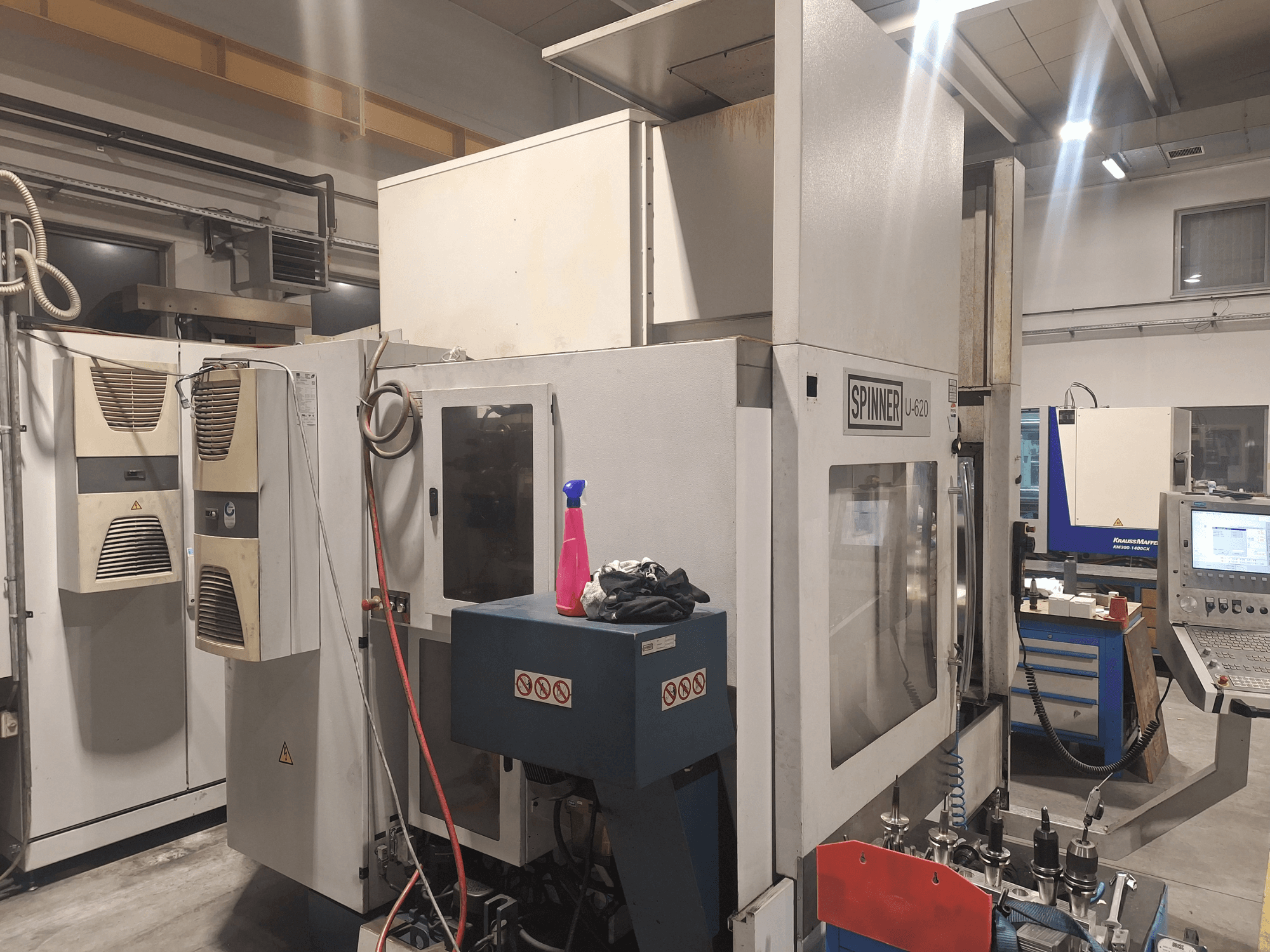 Spinner U-620 CNC-tööpink, näidatud esiplaanilt töökojas, kõrval tööpinkidel asuvad juhtpaneel ja erinevad tööriistad.