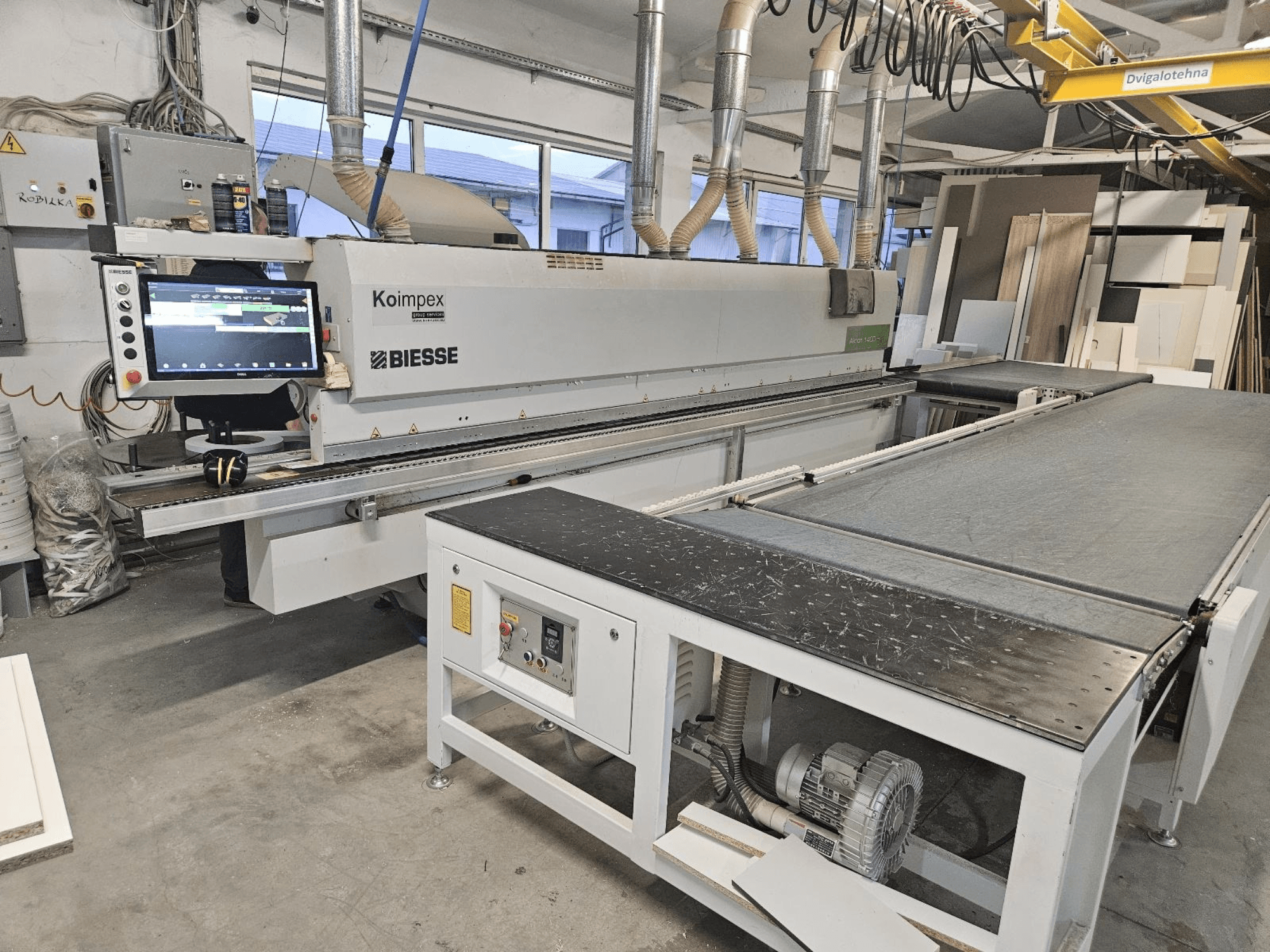 BIESSE Akron 1440 Servakandur töökojas, külgvaates on näha juhtpaneel ja konveierilint.