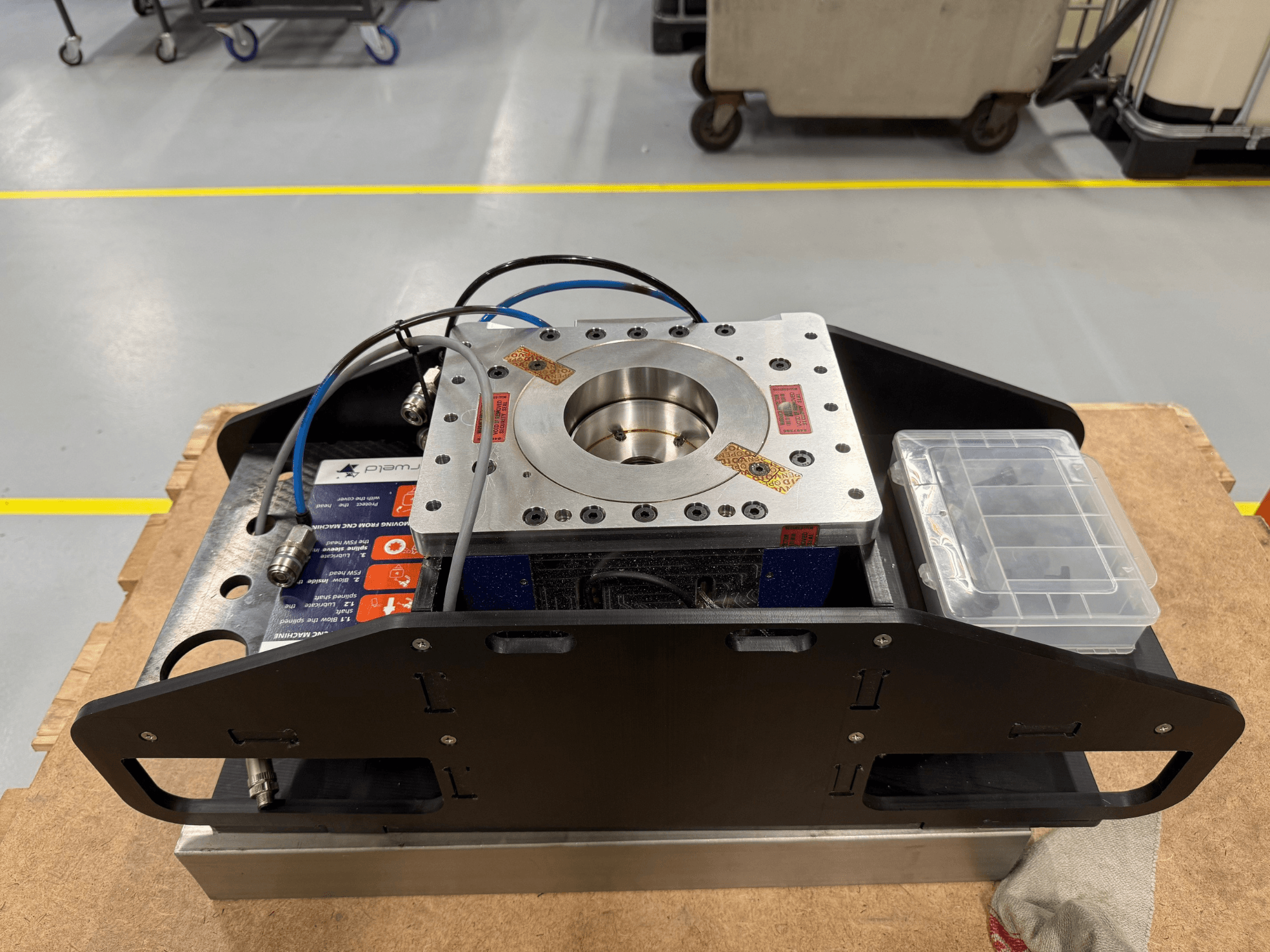 Töödeldud metallkomponent siniste kaablite, tarvikute korpuse ja lameda alusega, näidatud ülaltvaates, ideaalne mehaanilisteks rakendusteks.