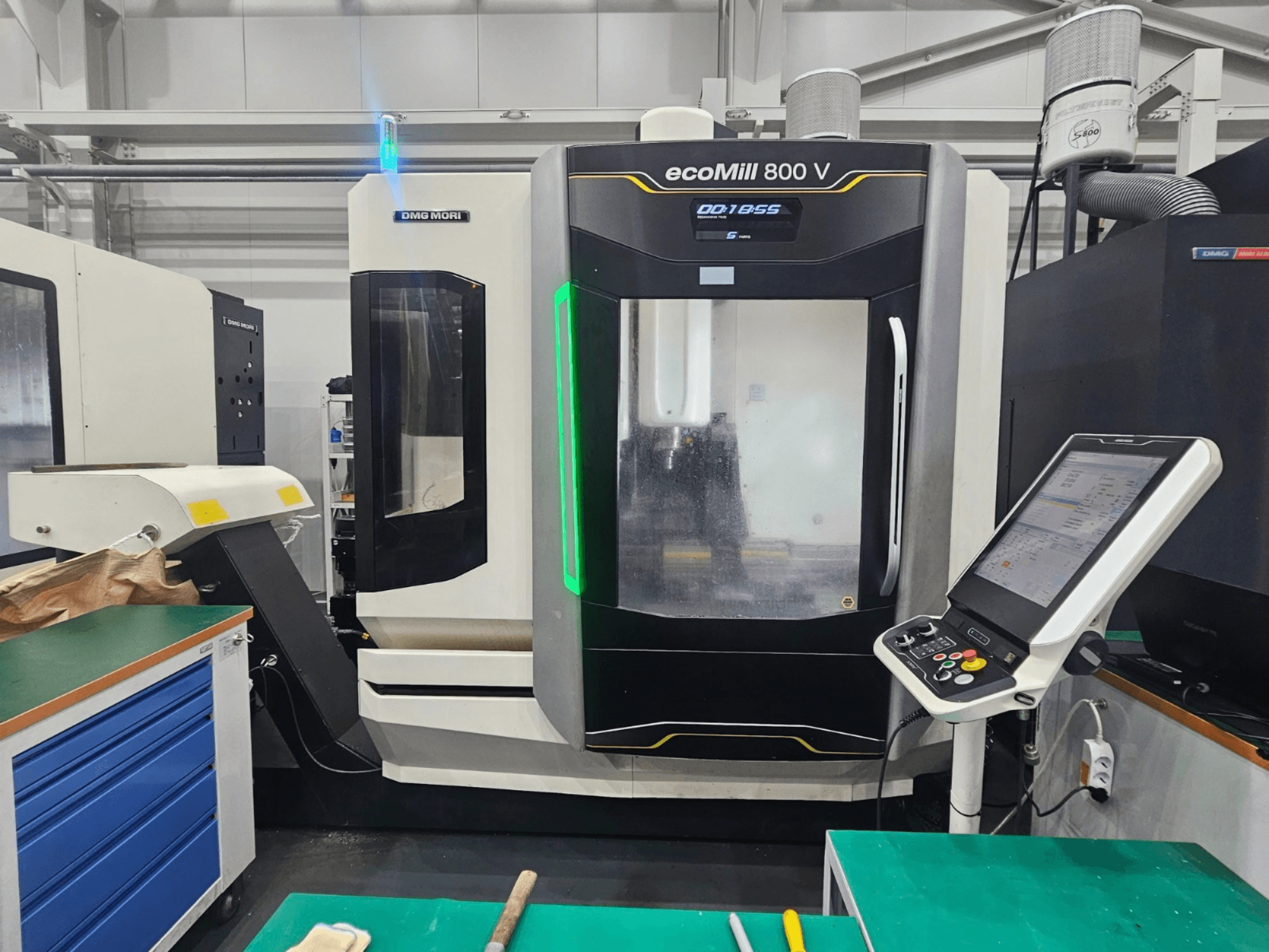 DMG MORI ecoMill 800 V vertikaalne töötlemiskeskus, vaade eest, millel on näha juhtpaneel ja masina üksikasjad.