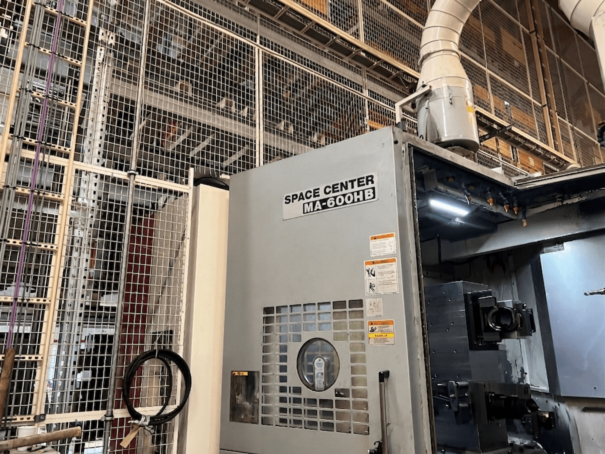 Okuma MA-600HB horisontaalne töötluskeskus, esiplaanil, tööpaneel ja jahutusvedeliku pihustid nähtavad.