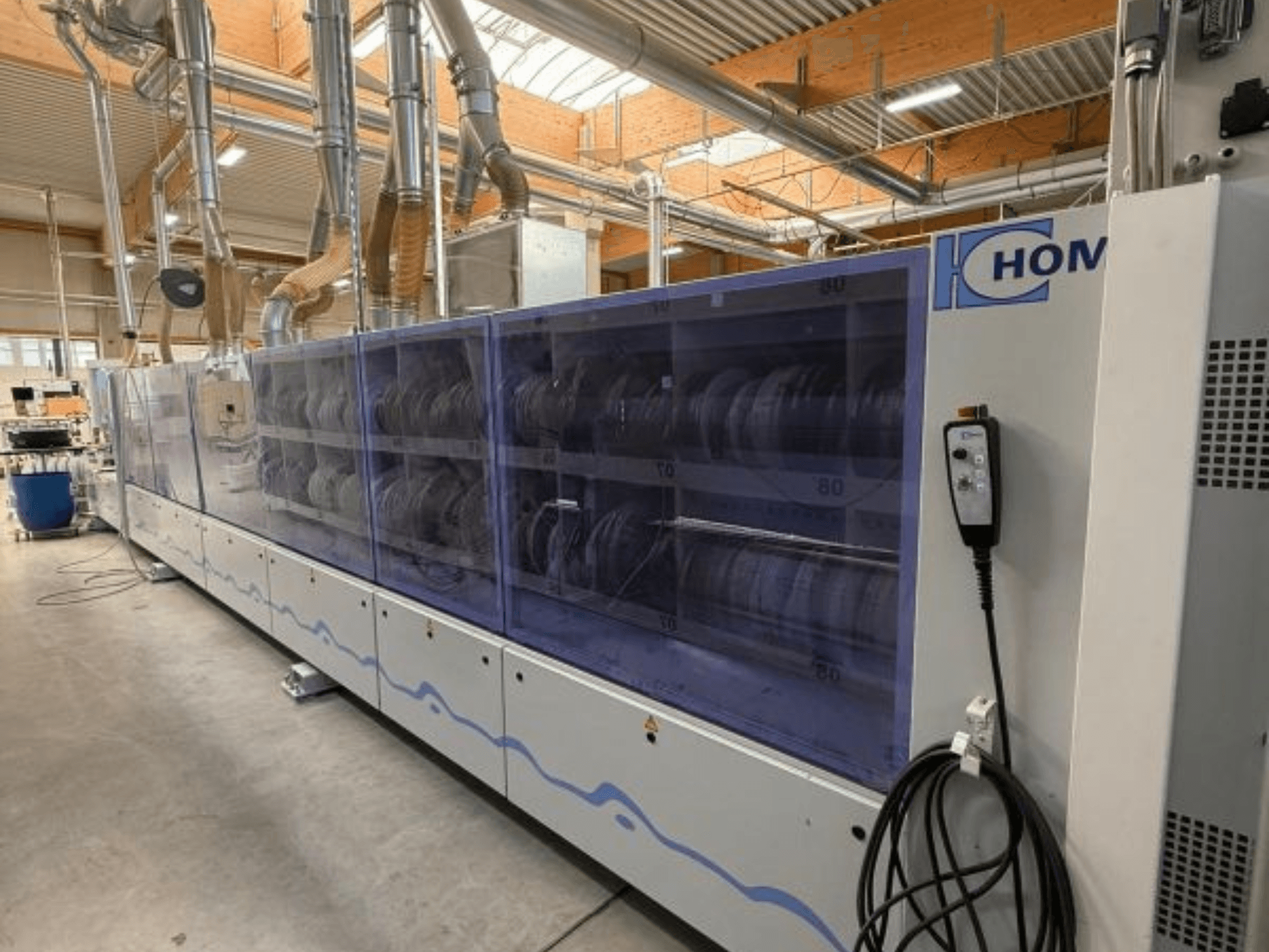 HOM tööstuslik pesumasin, esiplaanil, läbipaistev paneel, millel kuvatakse nõusid; küljel asuv nuppudega juhtpaneel.