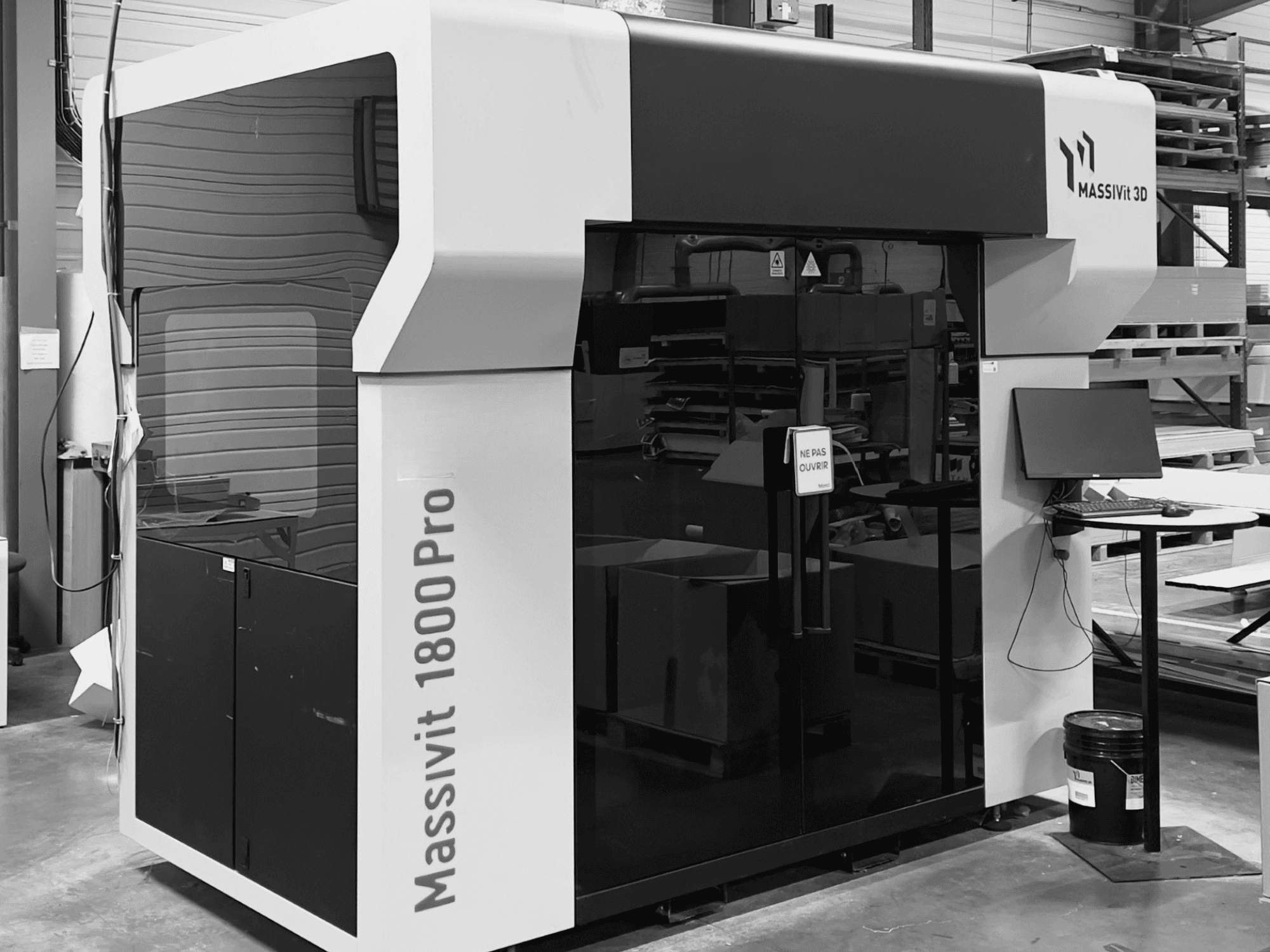 Plastist 3D-printer MASSIVIT 1800 PRO töökojas, vaade eest, kus on näha arvutitöökoht ja juhtpaneel.