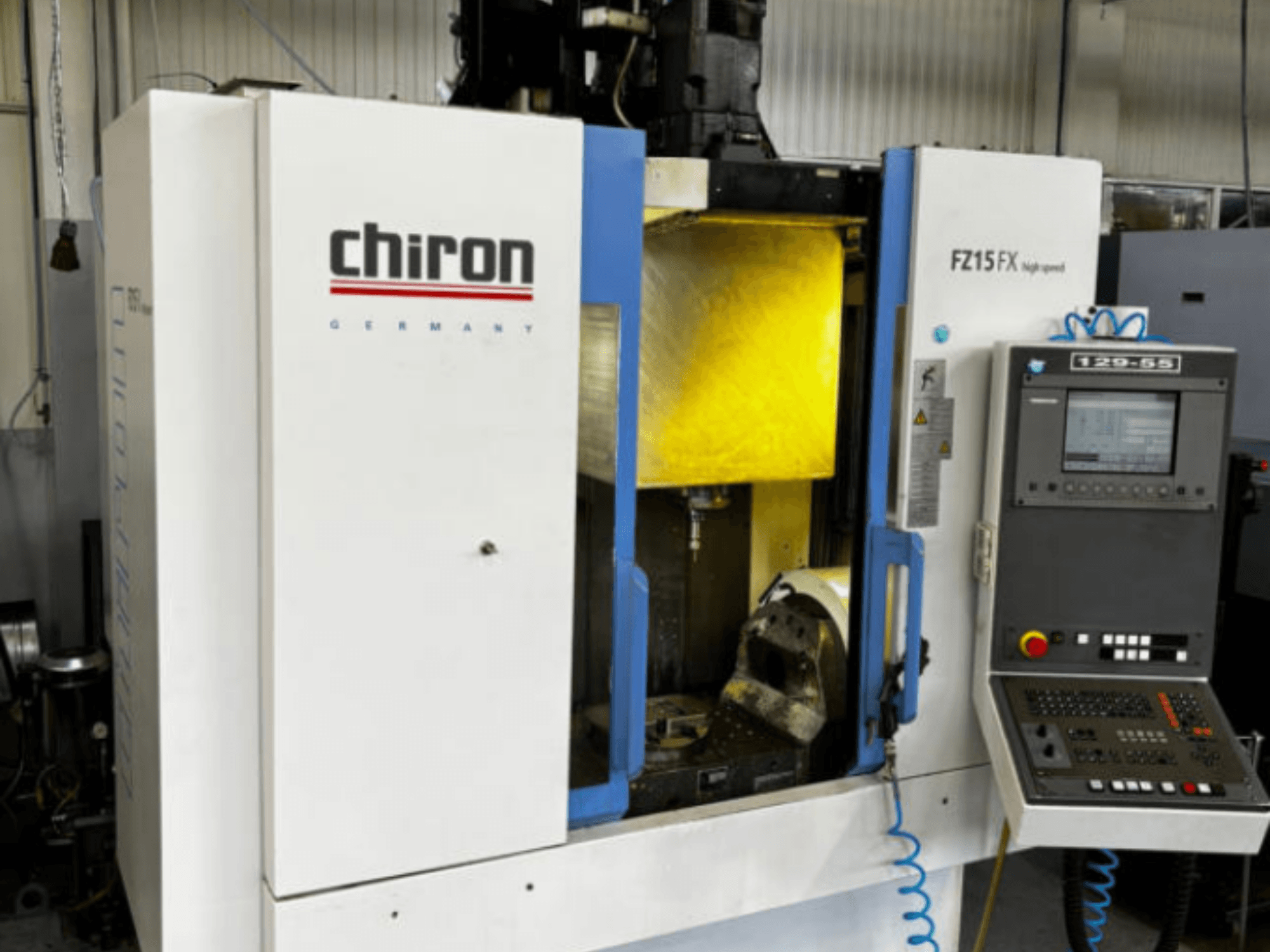 CHIRON FZ 15FX vertikaalne töötlemiskeskus, vaade eest, millel on näha juhtpaneel ja töötlemisala koos tööriistadega.