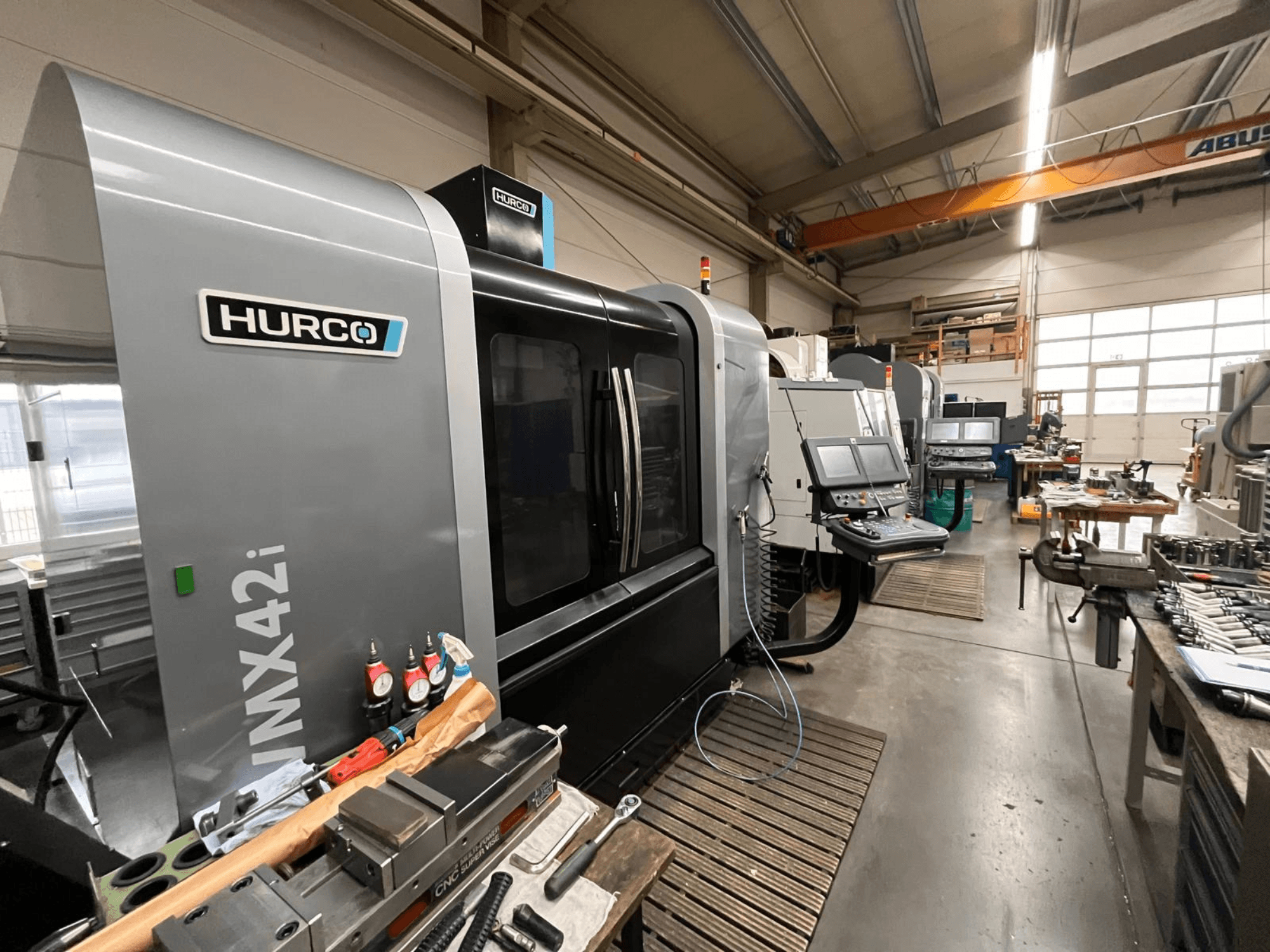 Hurco VMX42i CNC-tööpink töökojas, esivaade. Omadused juhtpaneel, hall korpus ja tööstuslik ümbrus.