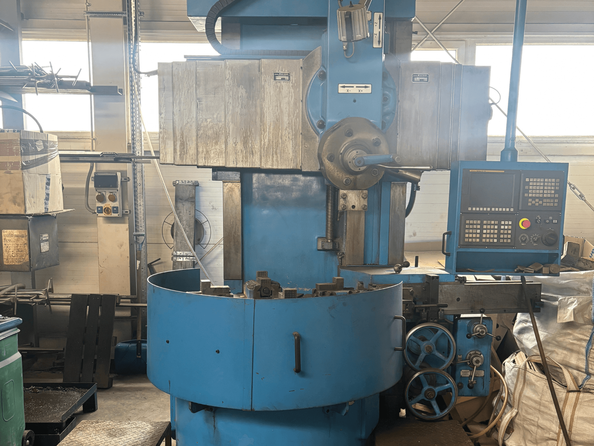 Tundmatu kaubamärgiga tööstuslik freespink, esiplaanil, sinise väliskülje ja digitaalse juhtpaneeliga.