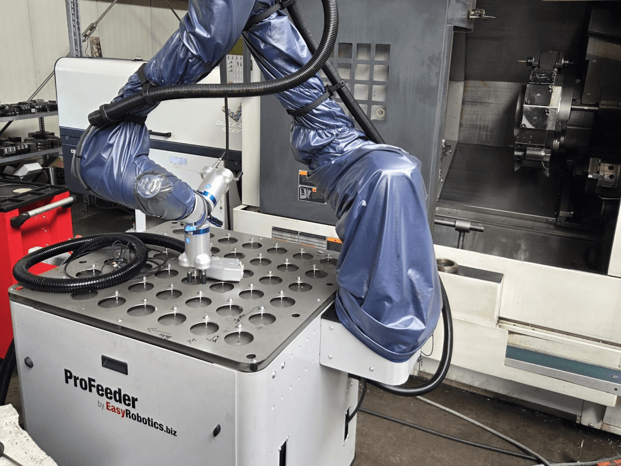 Koostöörobot EASYROBOTICS ProFeeder esiplaanil, robotkäsi paigutatud üle perforeeritud metalllaua.