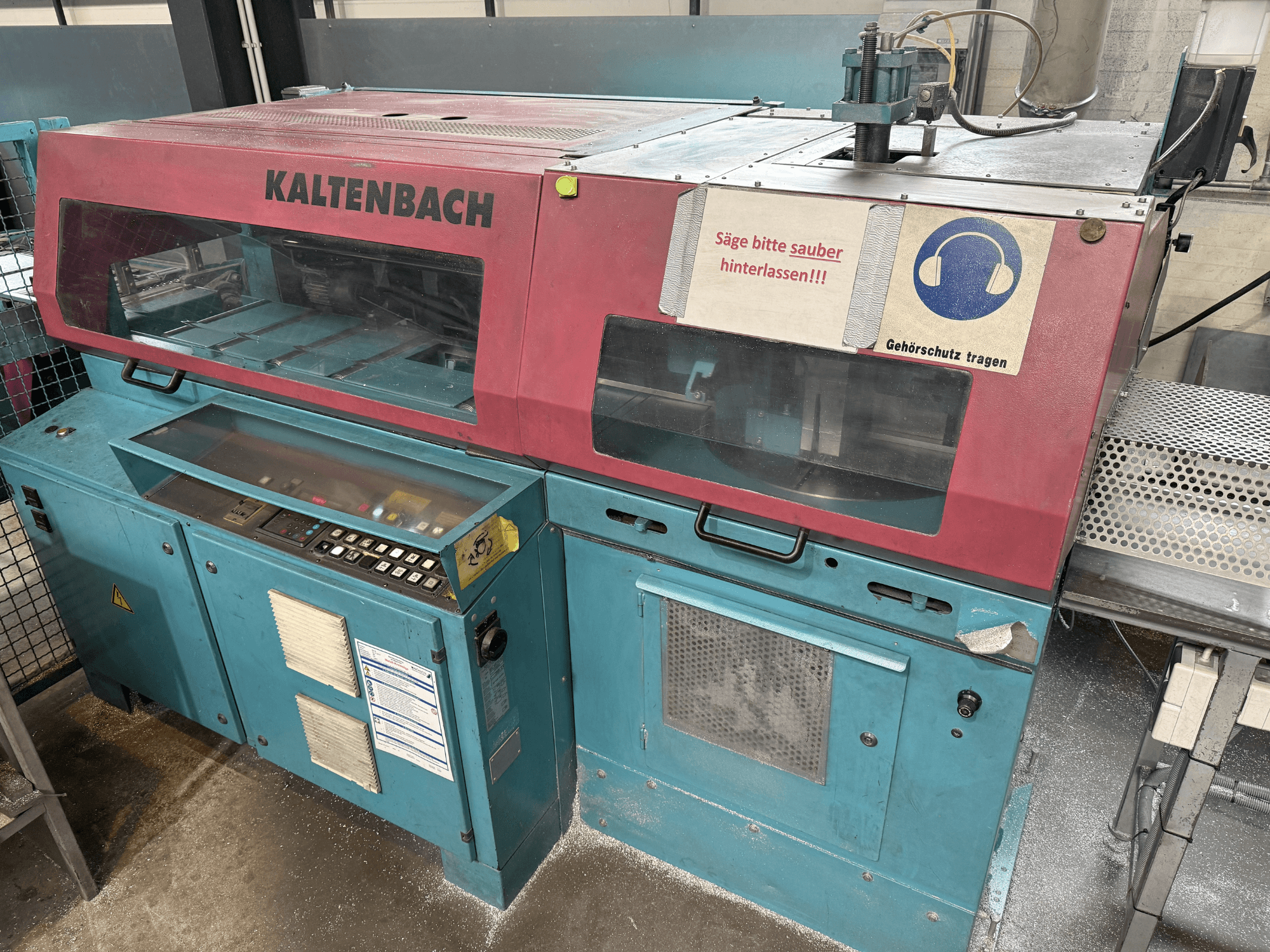 KALTENBACHi tööstuslik lõikemasin, esiplaanil, juhtpaneel ja kuulmiskaitse ohutusmärk.