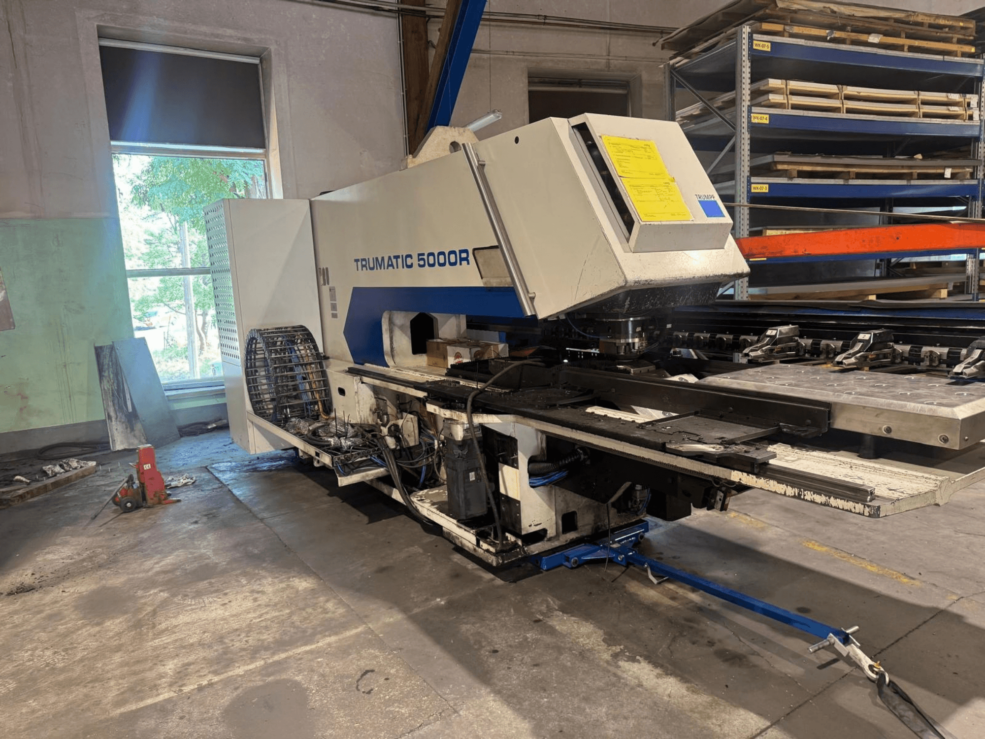 Töökojas asuv CNC-stantsimismasin TRUMPF TRUMATIC 5000R, esivaade, millel on näha juhtimispaneel ja stantsimisala.