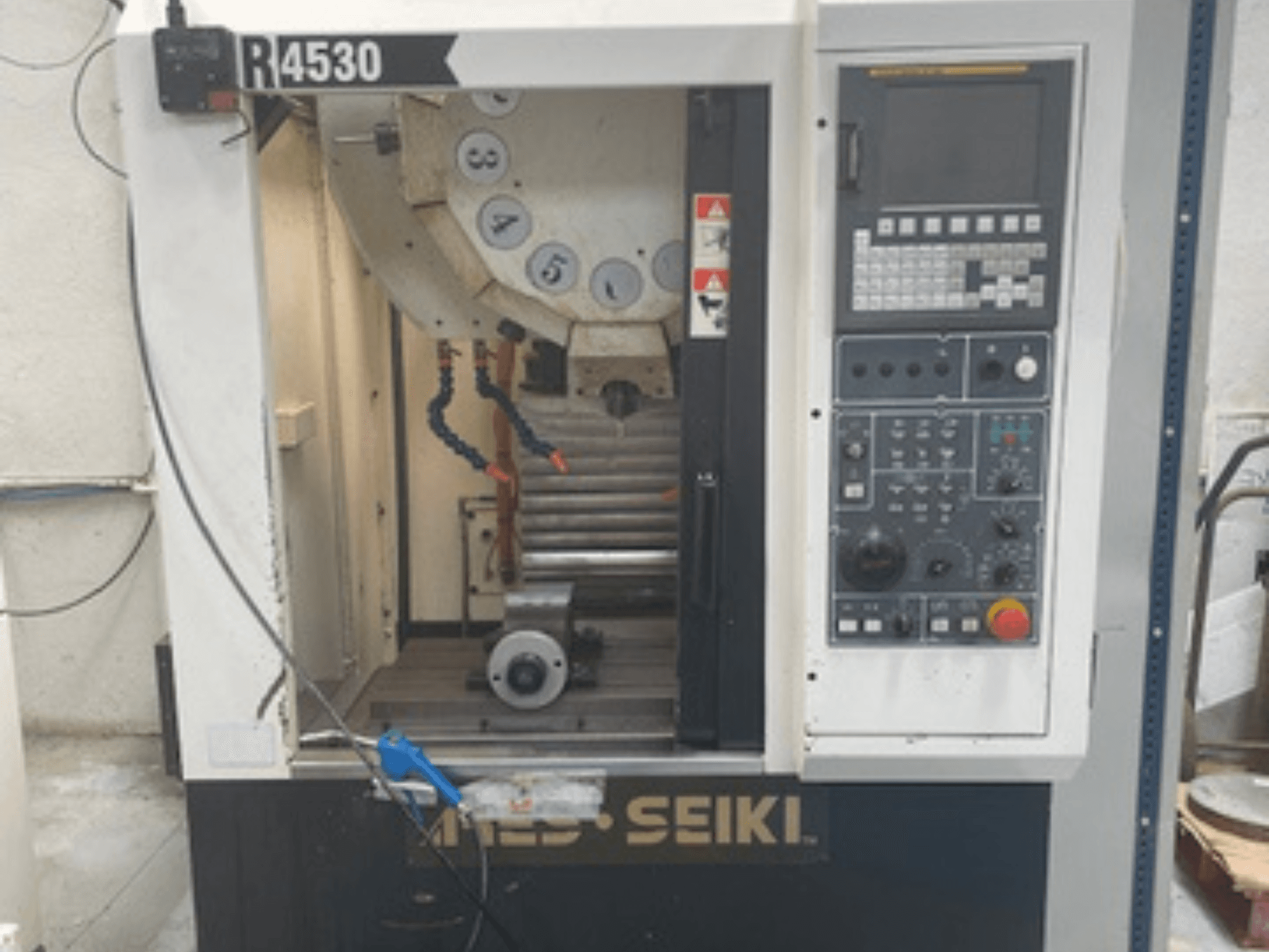 Vertikaalne töötluskeskus ARES-SEIKI R4530, esiplaanil on juhtpaneel ja tööpiirkond koos spindli ja jahutusvedeliku süsteemiga.