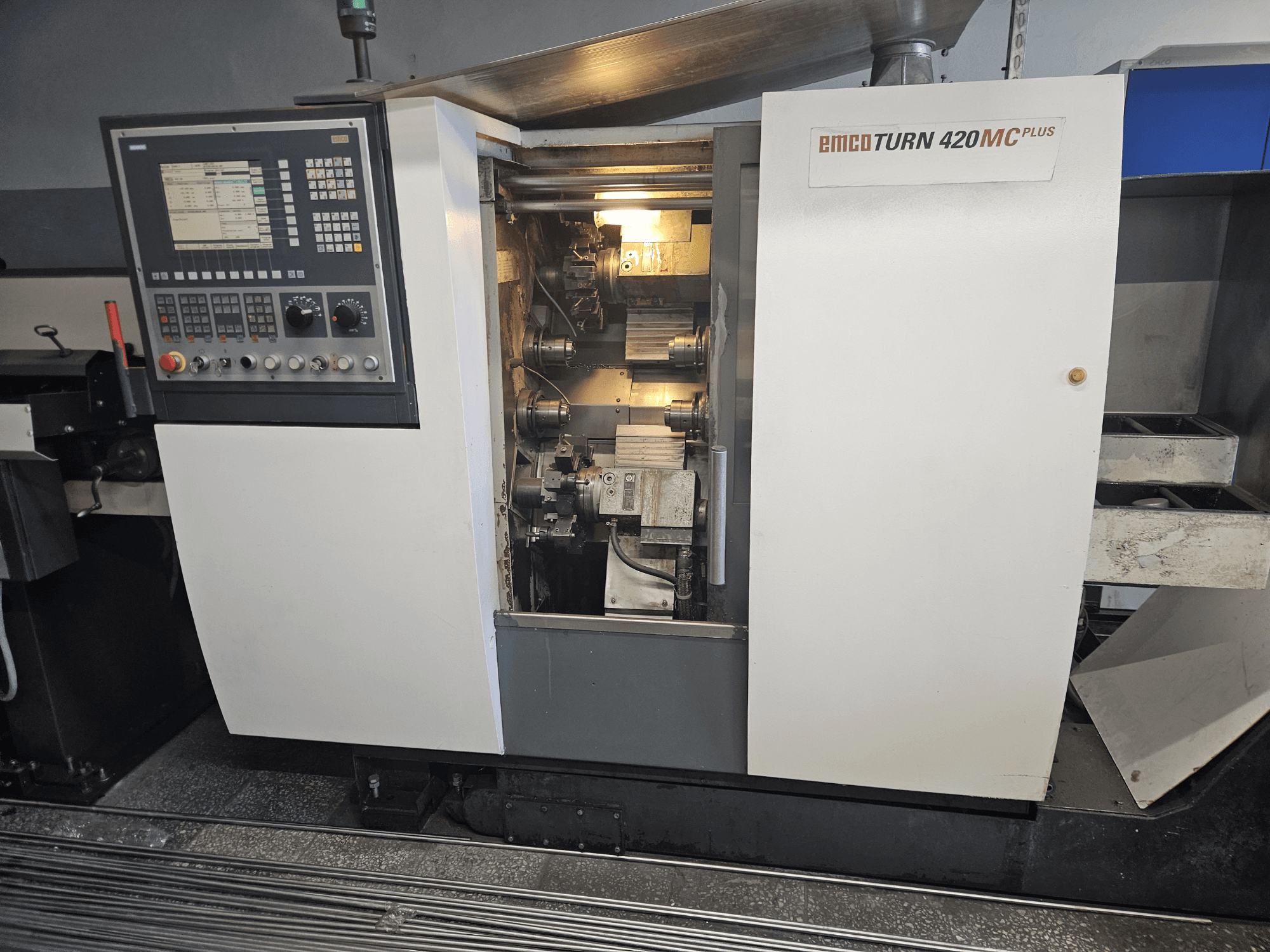 EMCO TURN 420 MC Plus mitmikspindliline masin, esiplaanil on näidatud juhtpaneel ja sisemised komponendid.