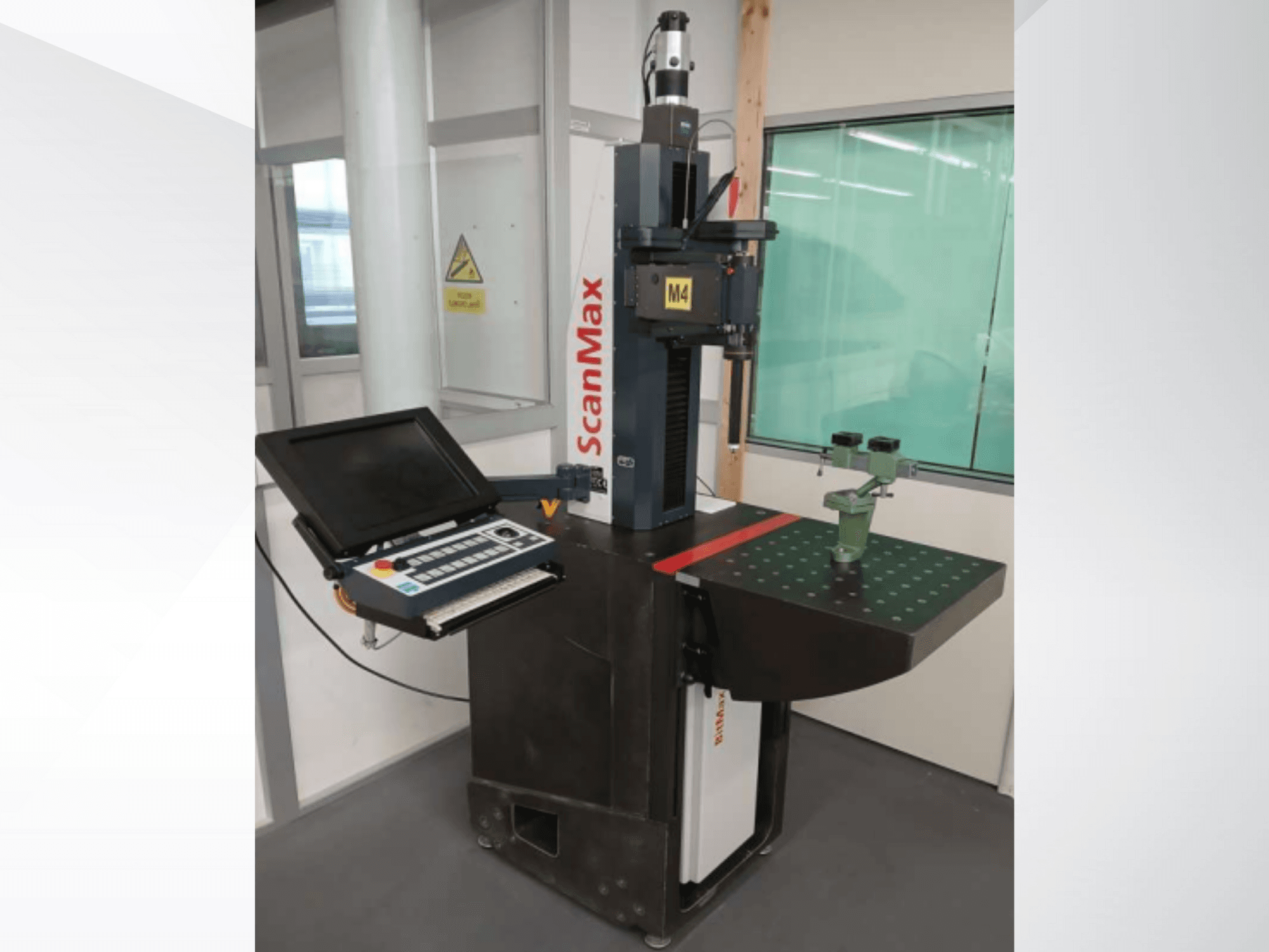 ScanMax M4 mõõtmismasin, esikülg koos juhtpaneeli ja rohelise kalibreerimisseadmega punktiiriga töölaual.