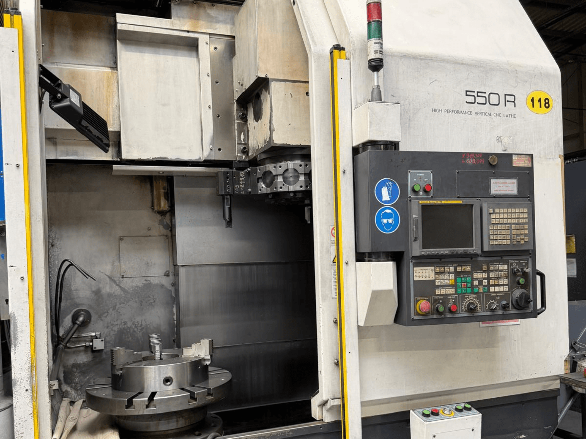 Suure jõudlusega vertikaalne CNC-teeninduspingi 550 R esiplaan, millel on näidatud juhtpaneel, pöörlev taldrik ja tööorganid.