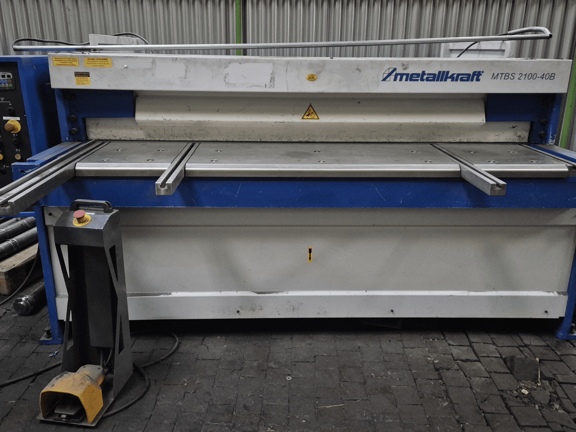 CNC lõikemasin Metallkraft MTBS 2100-40B, esiplaanil on juhtpaneel ja lõikelaud koos turvaelementidega.
