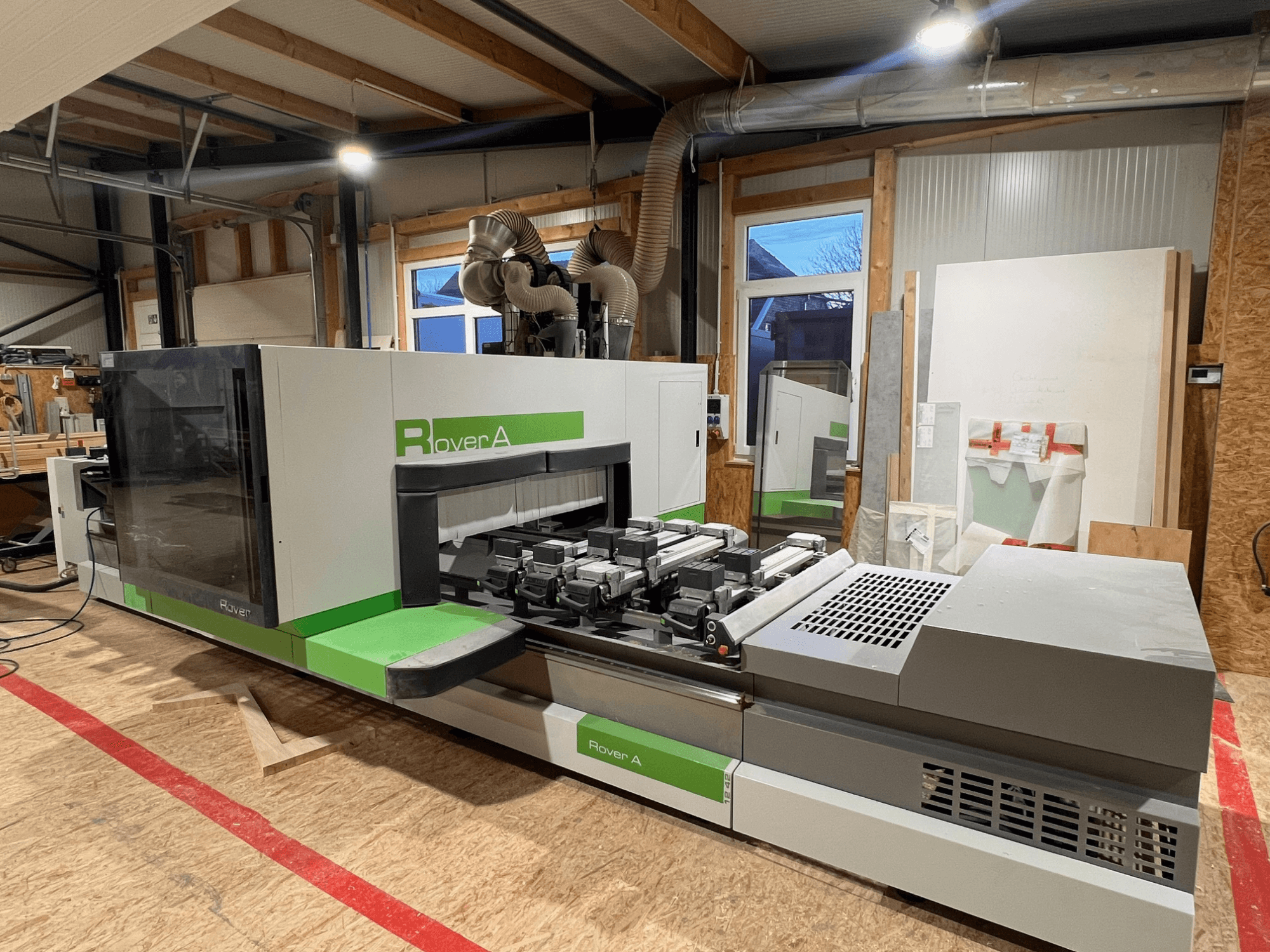 BIESSE Rover A 1242 CNC puidutöötluskeskus, esiplaanil on näidatud juhtpaneel ja lõikamisala töökojas.