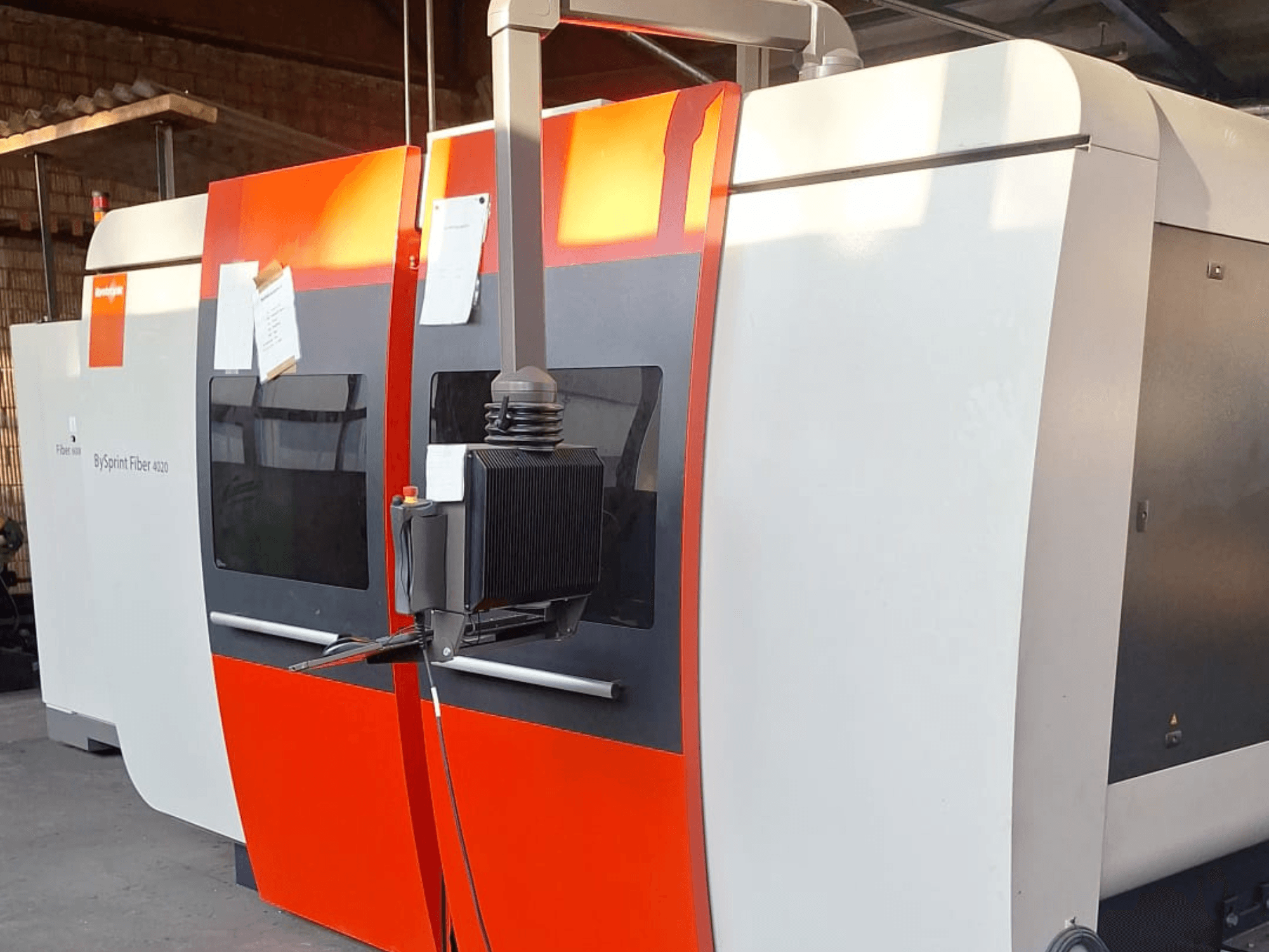 BySprint Fiber 4020 laserlõikamismasin, külgvaade, punane ja valge väliskuju, detailne juhtpaneel nähtav.