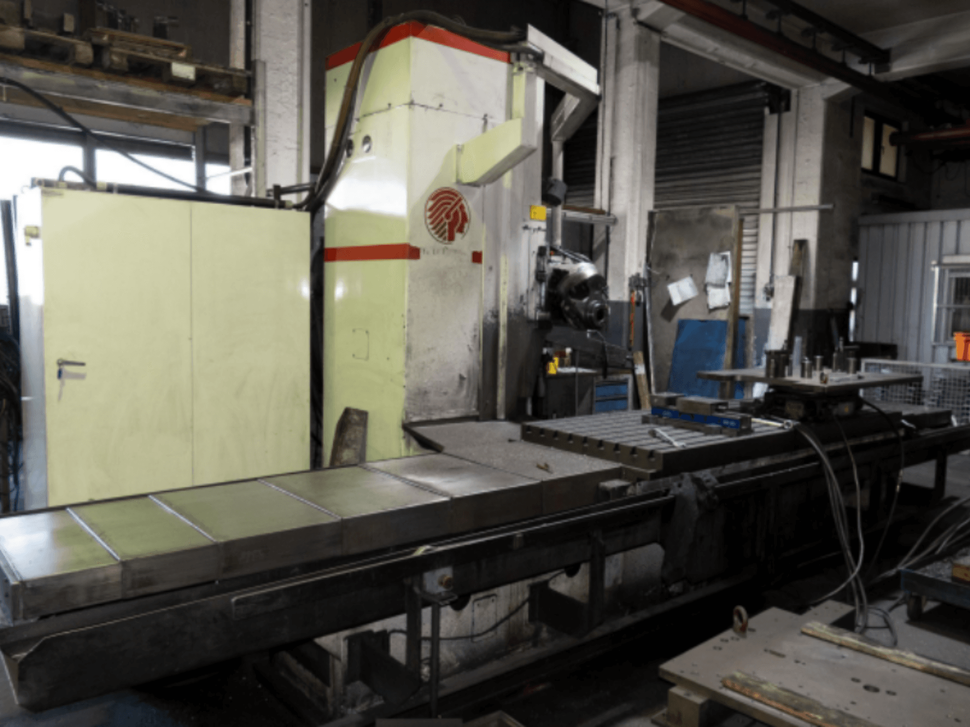 Suure lauaga tööstuslik freespink, külgvaade, kus näidatakse juhtimisseadmeid ja lisaseadmeid töökojas.