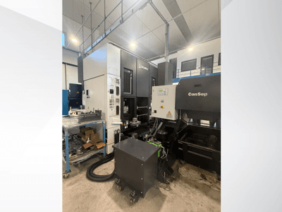 Okuma töötluskeskus koos ConSep seadmega, külgvaade, juhtimisseadiste ja tööstusliku seadistuse kuvamine, sealhulgas metallilaastude hoidla.