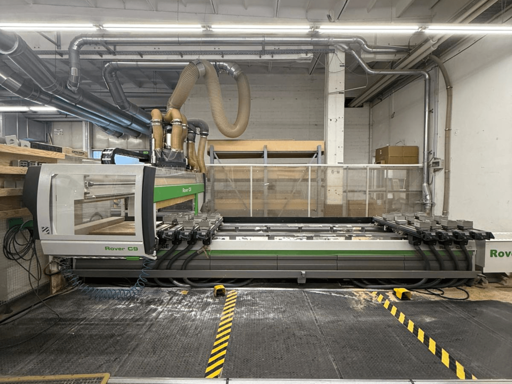 Rover C9 CNC-tööpink töökojas, esivaade, millel on mitu lõikepinda ja nähtav tolmueemaldussüsteem.