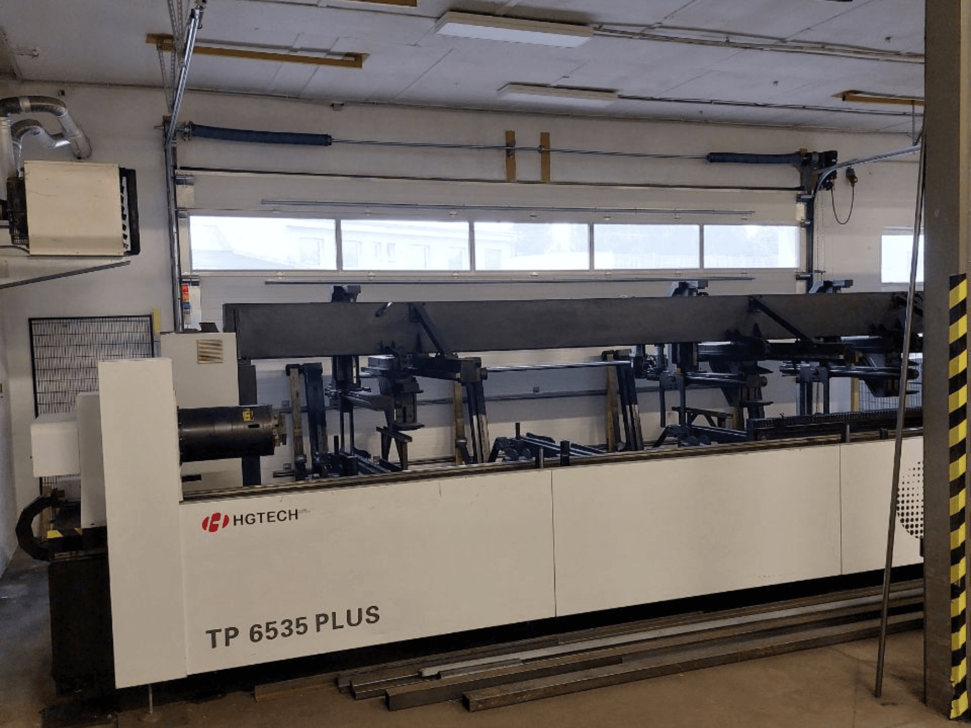 HGTECH TP 6535 PLUS, esiplaanil suur tööstuslik masin, millel on mitu kätt, mis on ette nähtud täppistöötluseks töökojas.