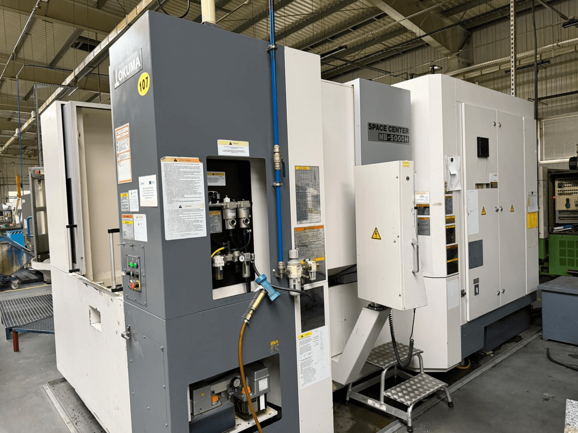 Okuma MB 5000H horisontaalne töötlemiskeskus, külgvaade juhtpaneelile ja masinaosadele tehases.