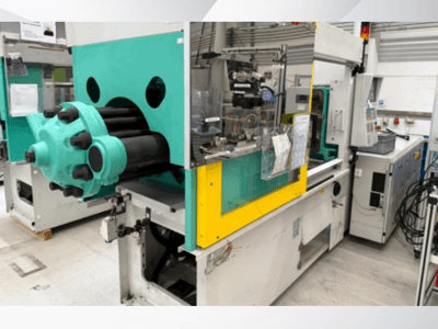 Helesinine ja kollane süstevormimismasin, esiplaanil, millel on nähtav vorm ja juhtpaneel koos siltidega.