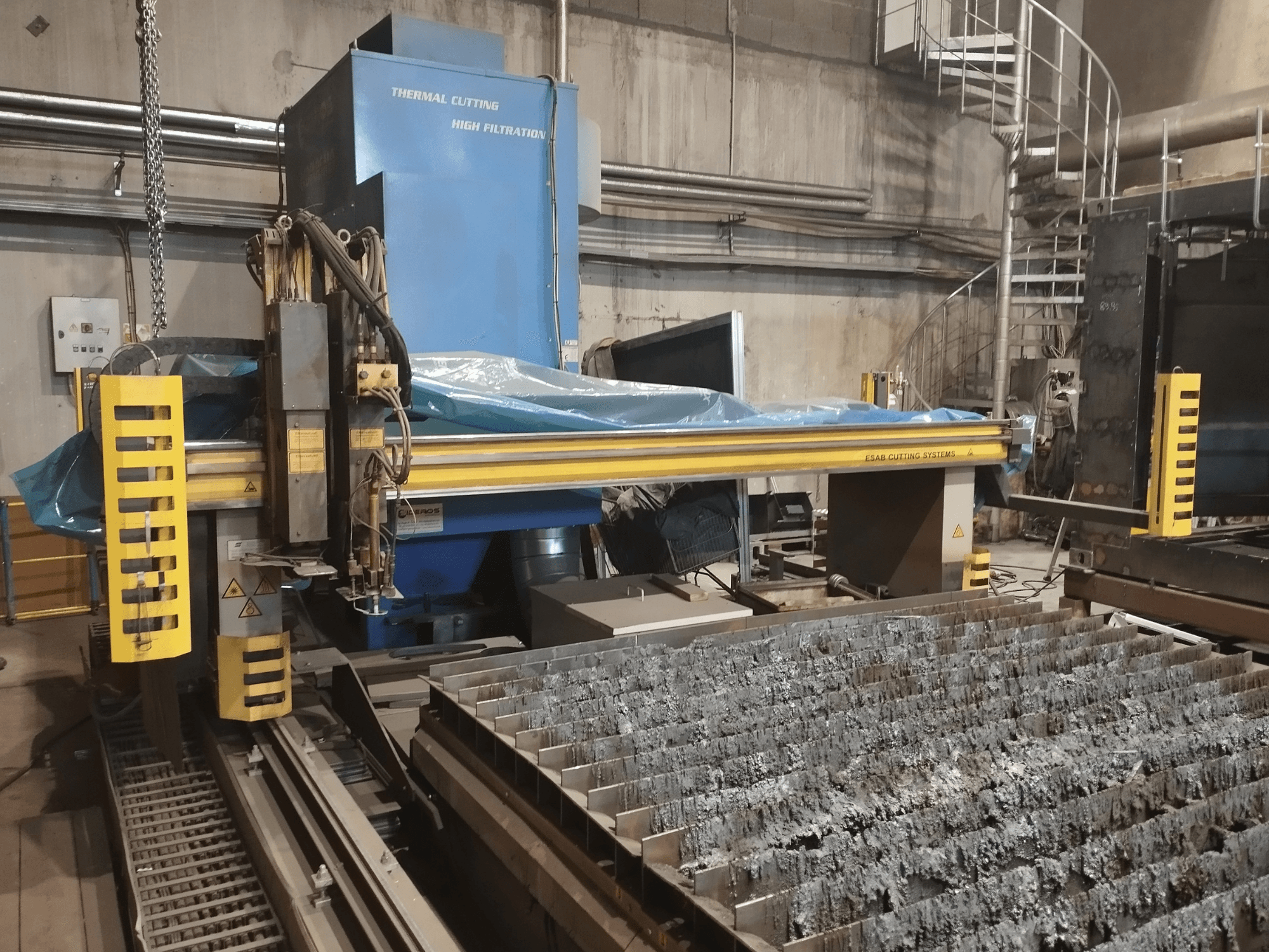 ESAB Combirex DX3500 autoplasmalõikusmasin, esiplaanil, kollaste turvaelementidega ja metalli lõikelauaga.