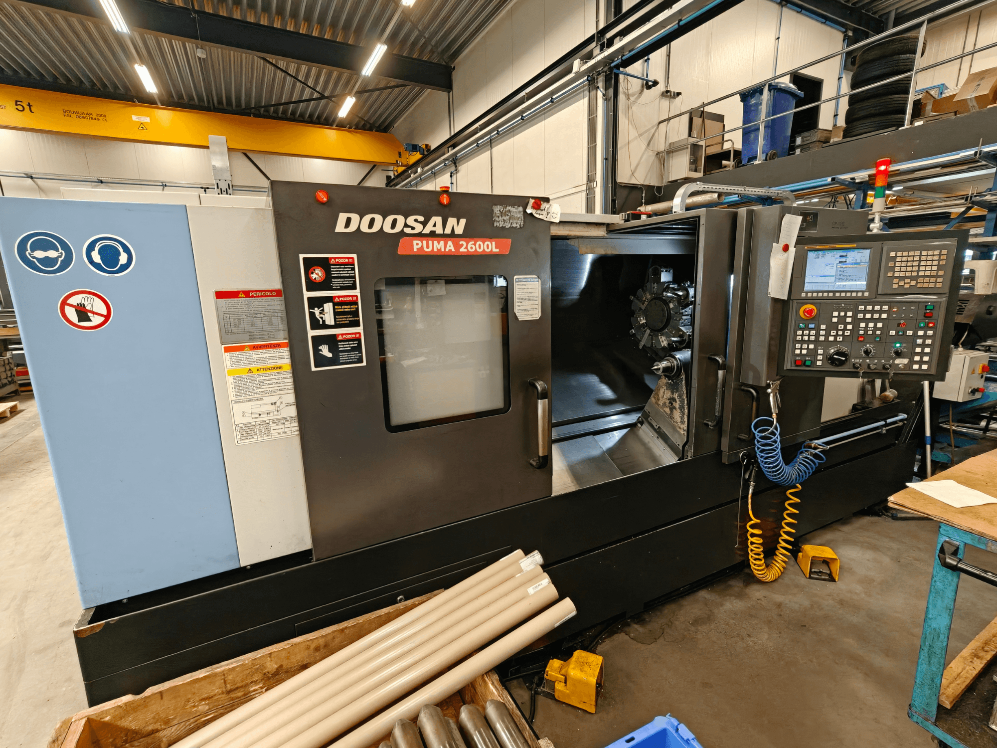 DOOSAN Puma 2600L horisontaalne treipink töökojas, külgvaates on näha juhtpaneel ja spindli ala.