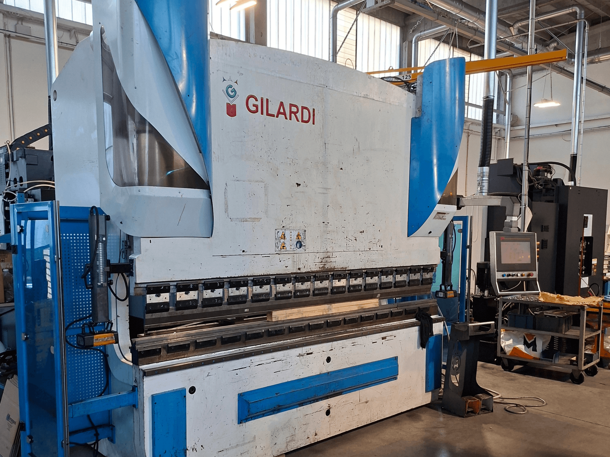 GILARDI Itaalia 3,25 hüdrauliline press, vaade eest, millel on näha juhtimisseadmed ja tootmiskeskkonna üksikasjad.