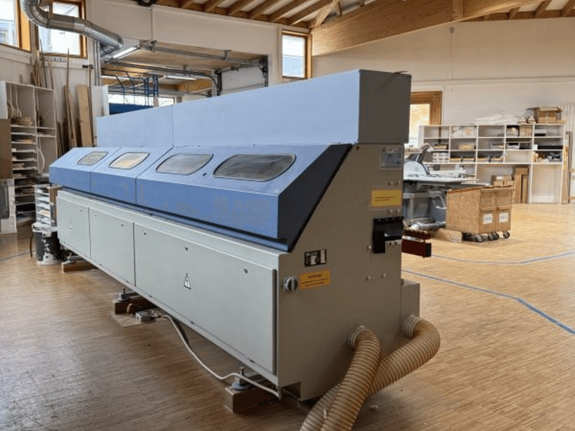 OTT Pacific V6-F servakäärimismasin külgvaates; sellel on pikk sinine ülemine osa ja juhtpaneel koos voolikukinnitusega.