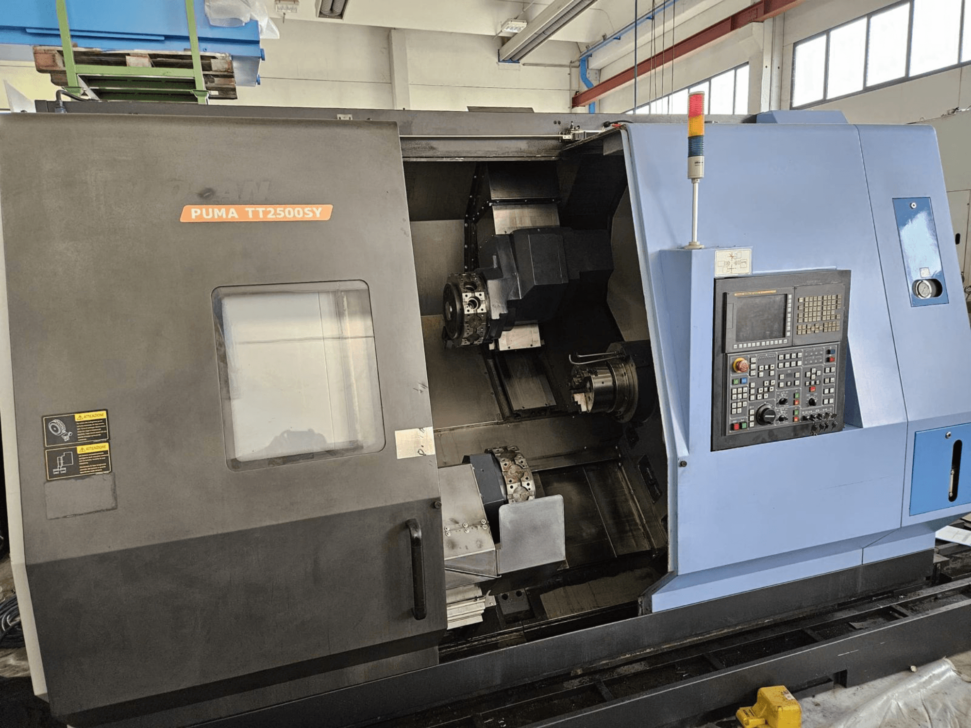 DOOSAN PUMA TT2500SY mitme spindliga treipink, esivaade, millel on näha juhtpaneel ja masina sisemuse üksikasjad.