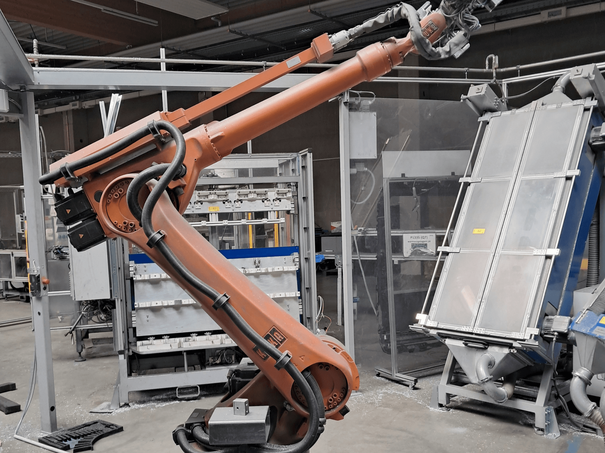 KUKA KR 30L16-2 robotkäsi tehase keskkonnas, külgvaade, millel on näha kaablid ja mehaanilised komponendid.