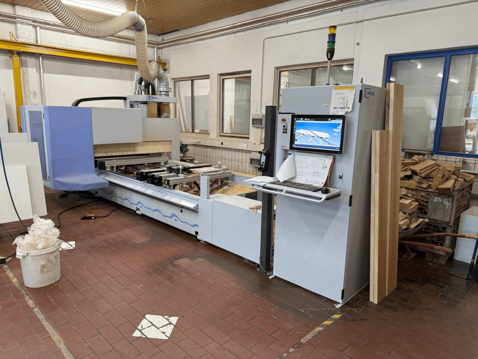 Weeke PROFI BMG211/32/12/K CNC-puidutöötluskeskus, vaade eest, millel on juhtpaneel ja puitdetailid ning tolmuärastussüsteem.
