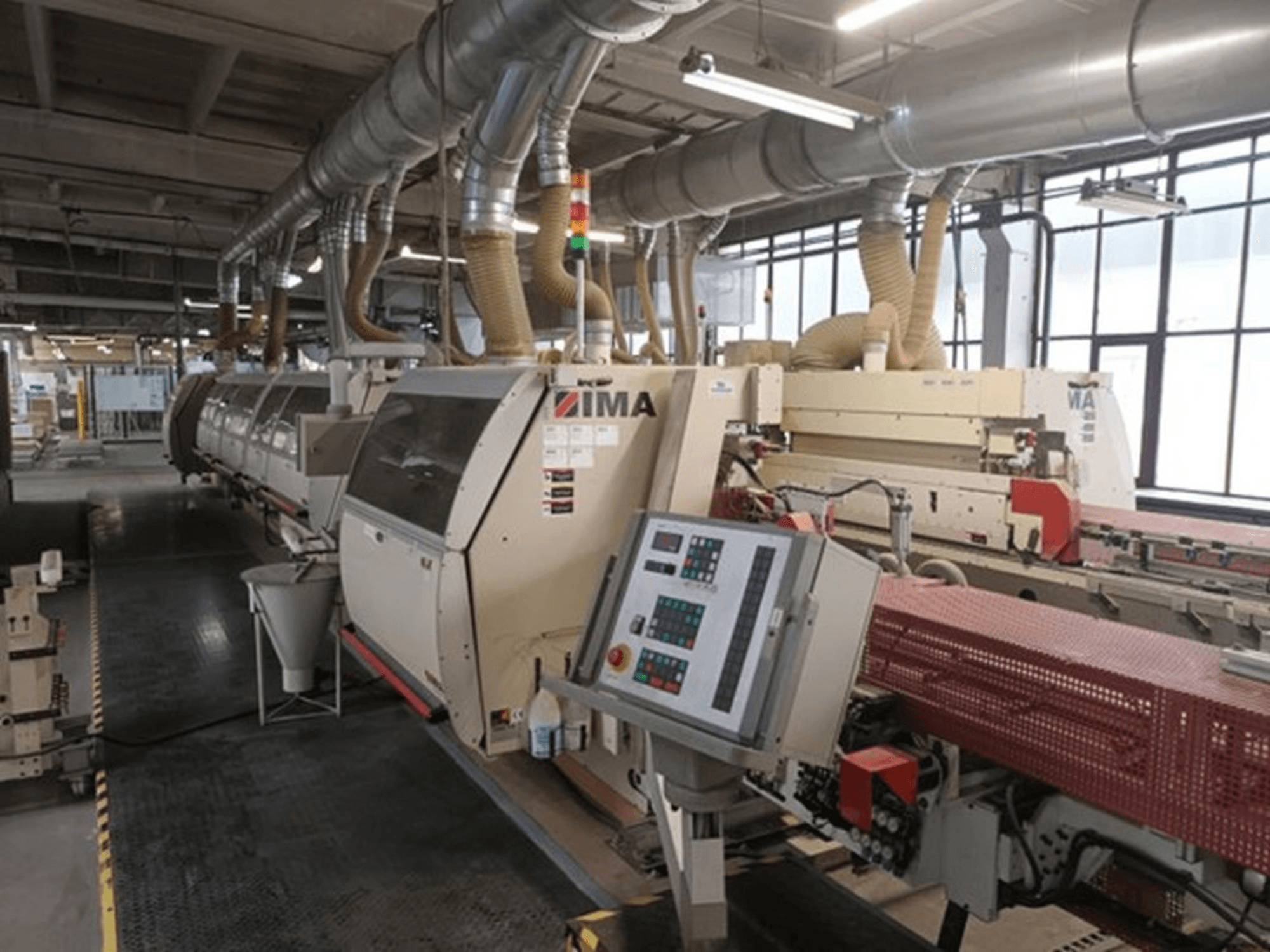 IMA tööstusmasinad tehases, esiplaanil, kus on juhtpaneelid ja tolmueemaldustorud.