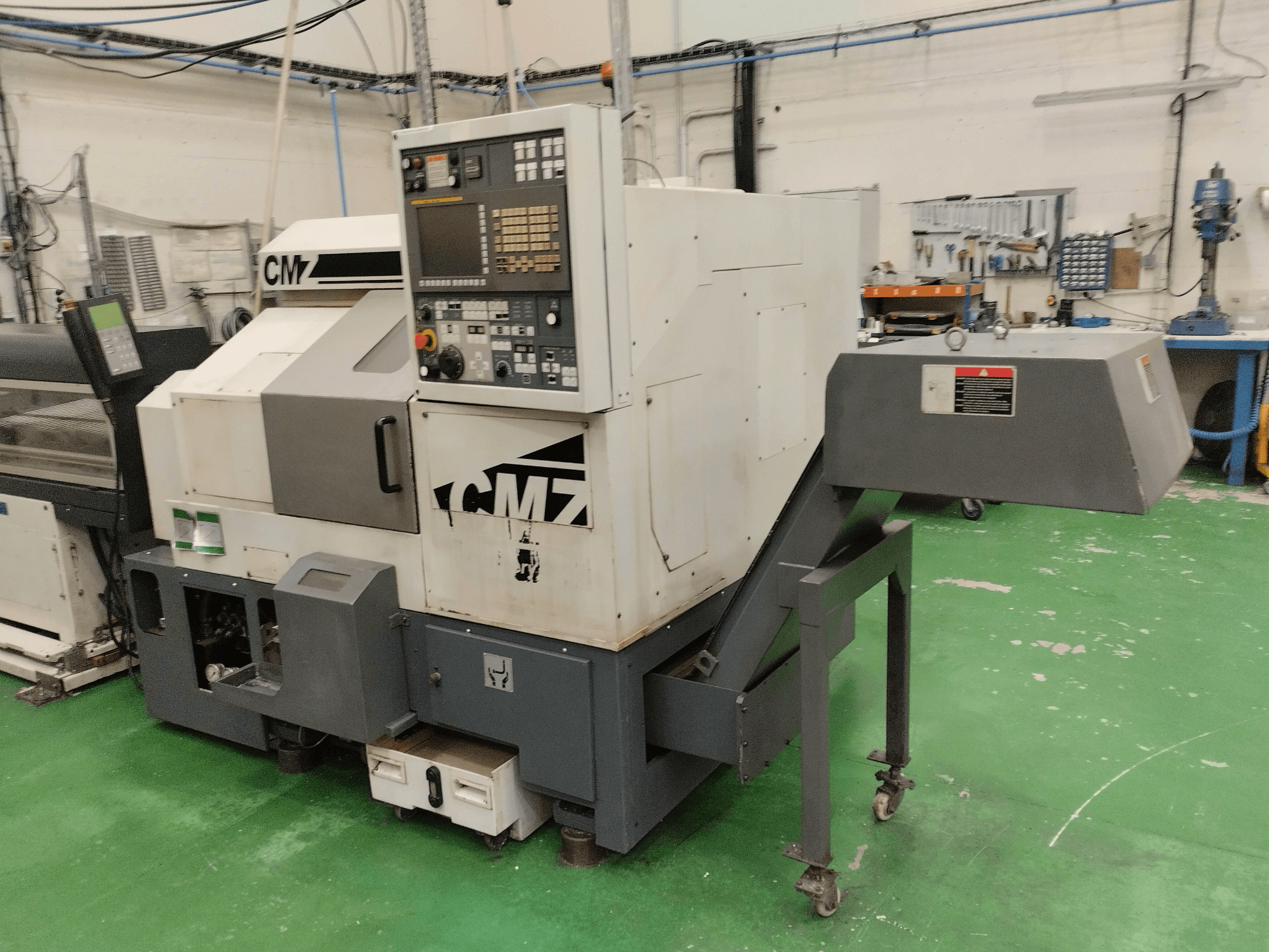 CMZ TB-67M treipingi keskus esiplaanil, kus on juhtpaneel ja söötmismehhanism, seadistatud töökojakeskkonda.