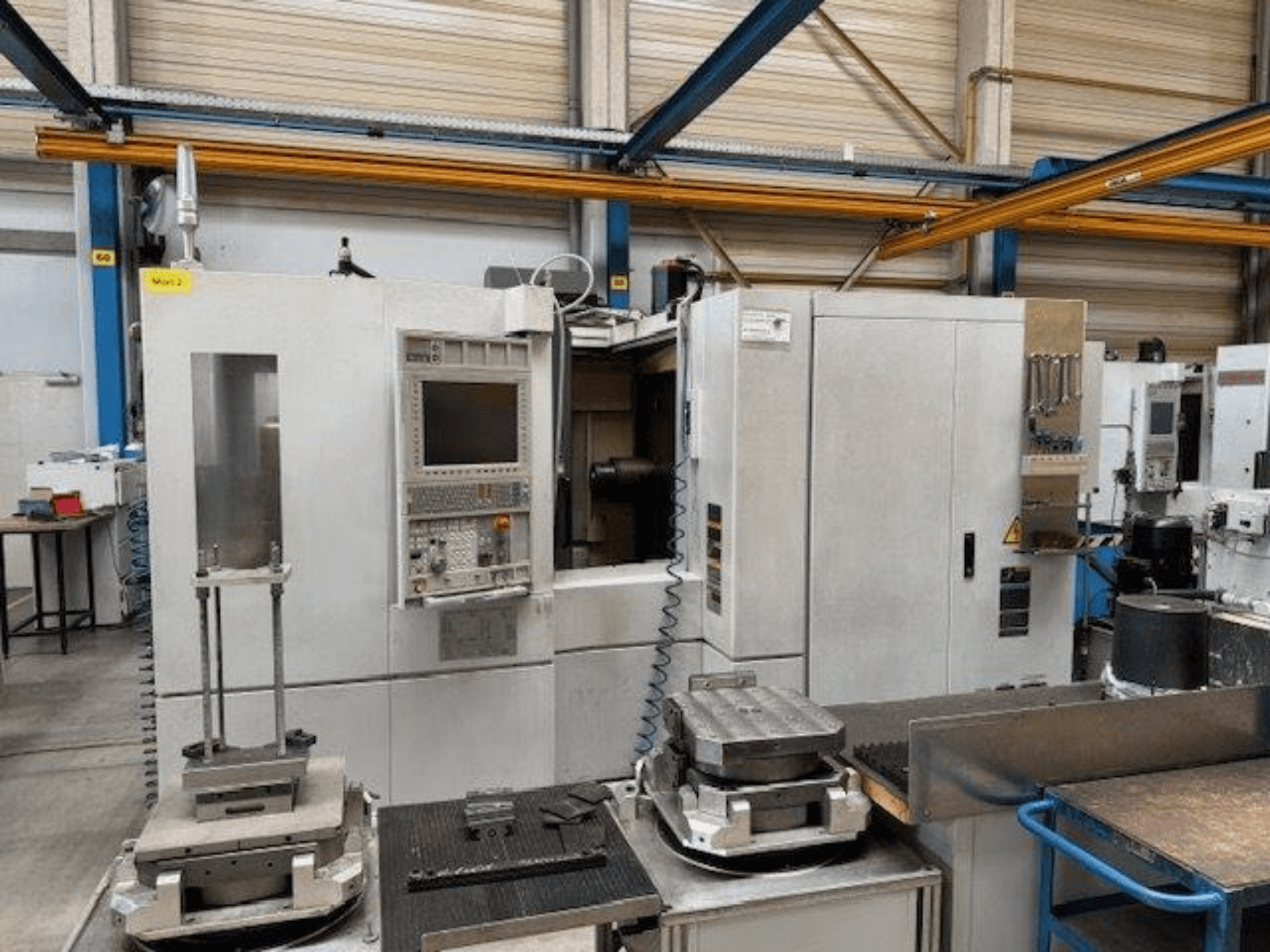 MORI SEIKI NH4000 DCG horisontaaltöötluskeskuse esiplaan, juhtpaneel ja töödetailid laual.