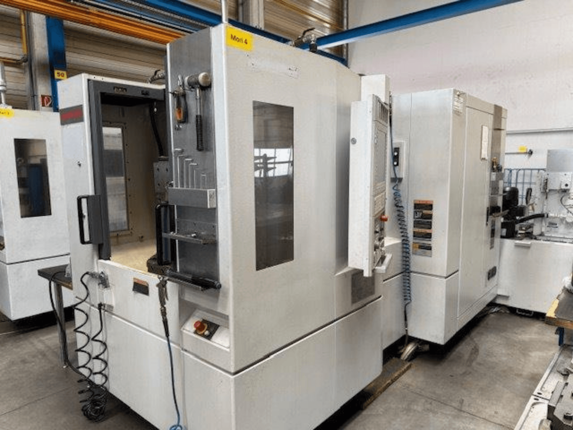 MORI SEIKI NH4000 DCG horisontaalne töötluskeskus esiplaanilt, millel on avatud uks ja juhtpaneeli detailid.