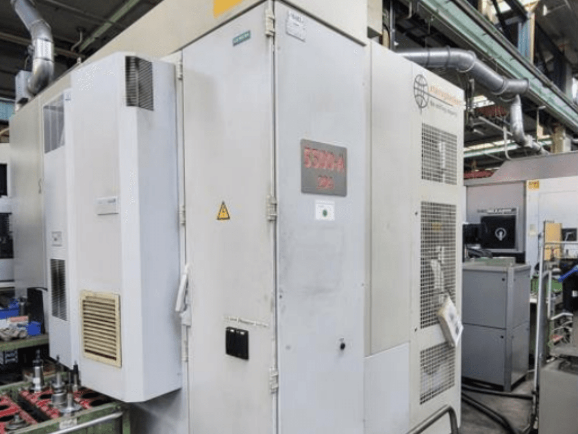 Starrag Heckert HEC 500 H/V horisontaalne töötluskeskus, külgvaade, kus on näha väliskülg koos ventilatsiooniavade ja hoiatussiltidega.