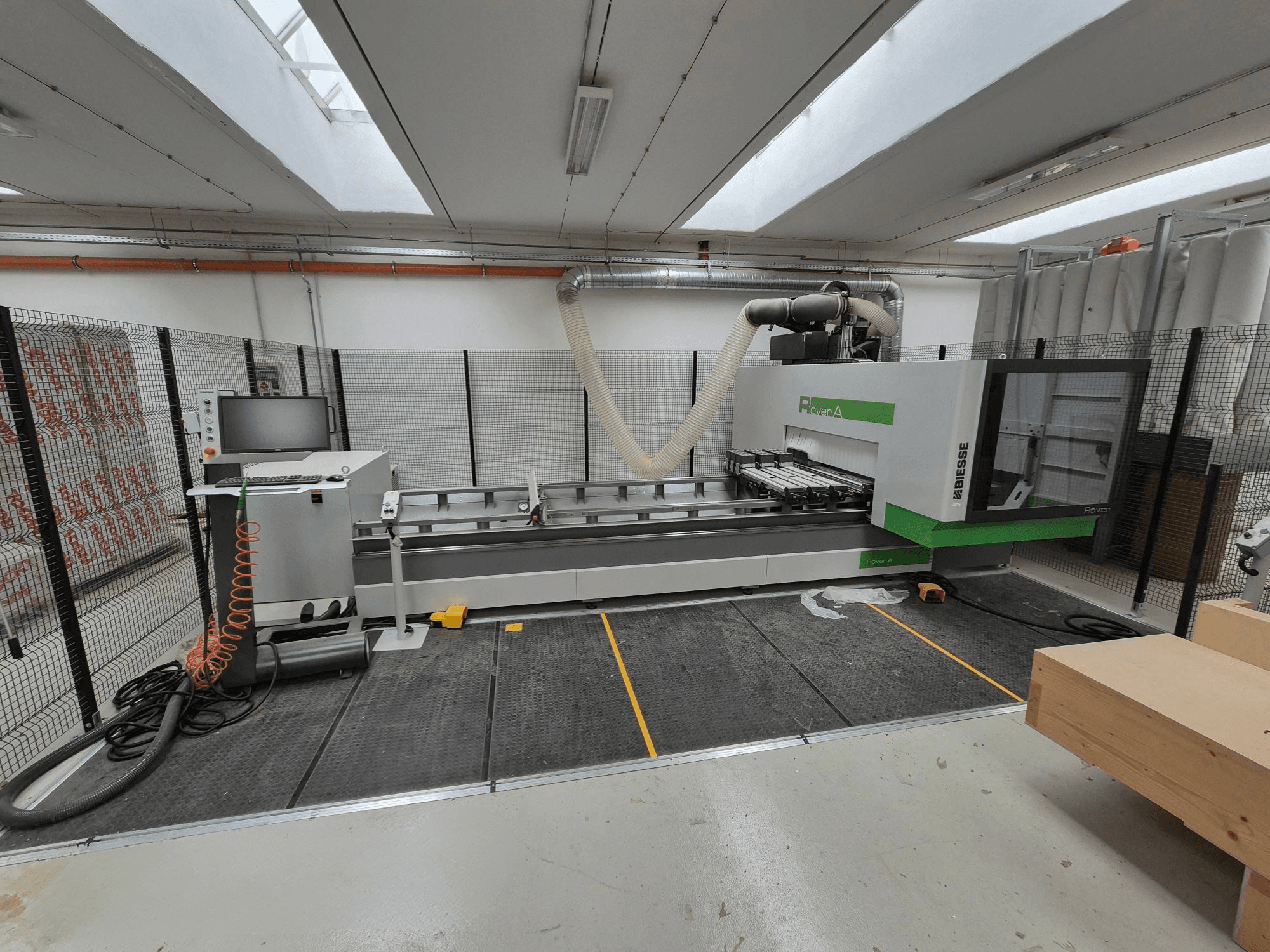 Biesse Rover CNC-masin töökojas, esiplaanil. Olemas on juhtpaneel, vaakumsüsteem ja tööpind.